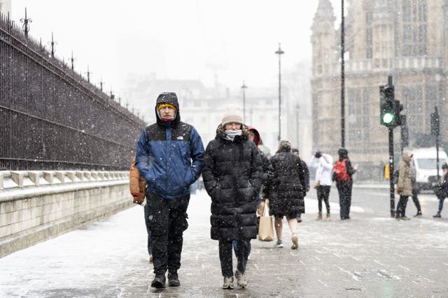 People in the snowy conditions in Westminster on Tuesday (Ben Whitley/PA)