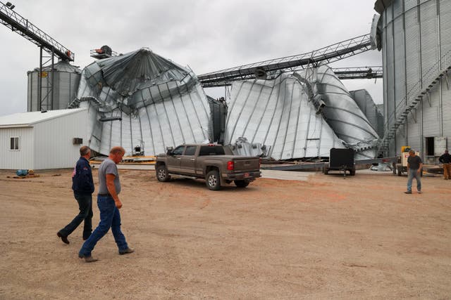 <p>North Dakota Governor Kelly Armstrong walks by silos damaged by an EF5 tornado in Enderlin last June</p>