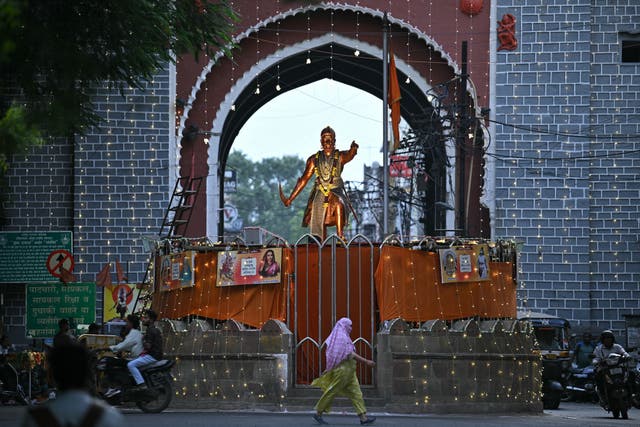 <p>A woman walks past the illuminated Shivaji Square, in Nagpur</p>
