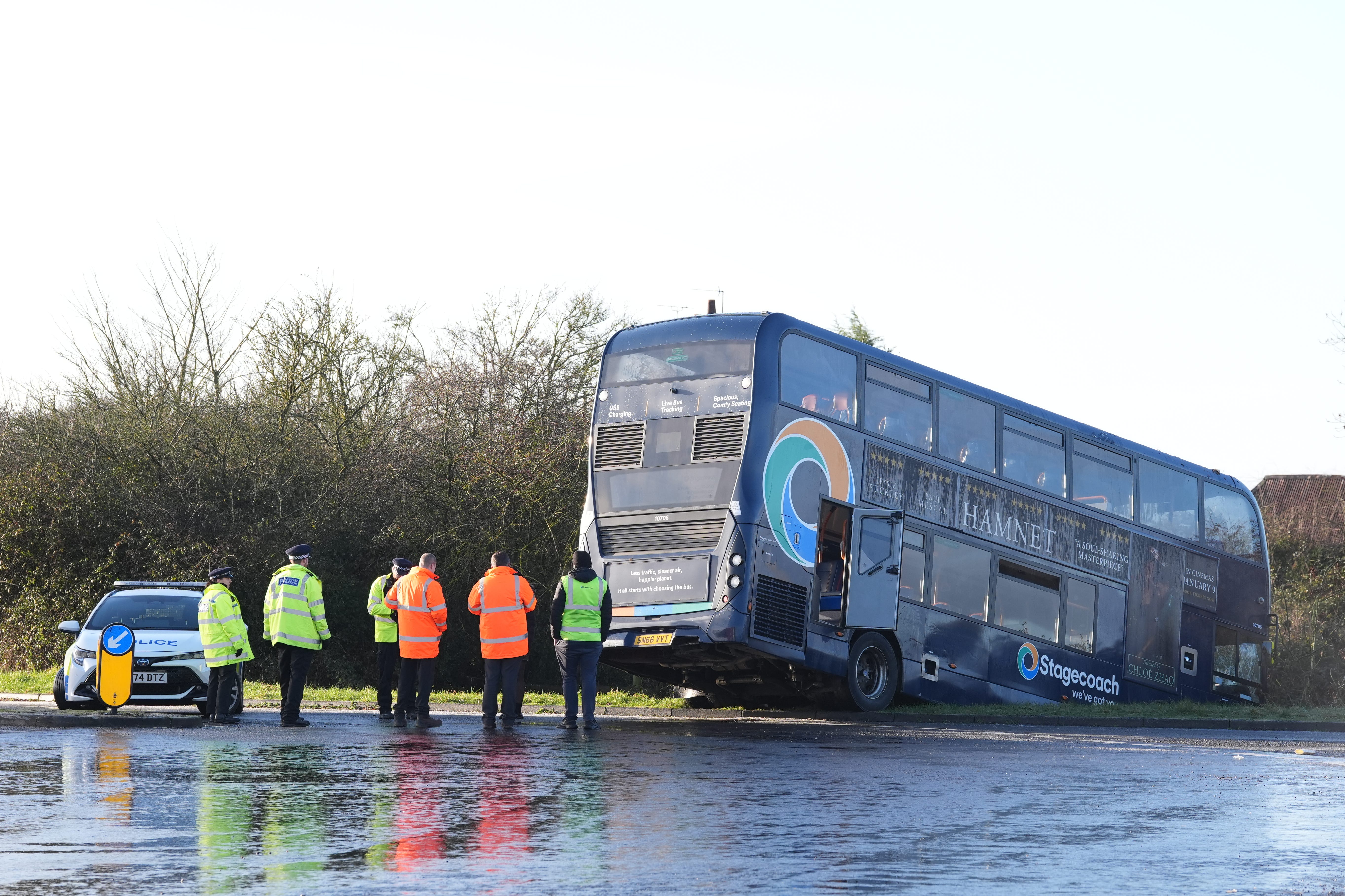 <p>Police at the scene after a bus crashed into a ditch near Ashford in Kent</p>