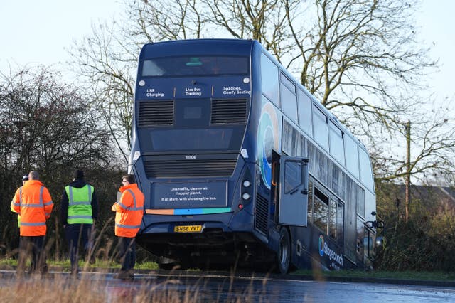 <p>Police at the scene after a bus carrying school children crashed into a ditch near Ashford in Kent (Gareth Fuller/PA)</p>