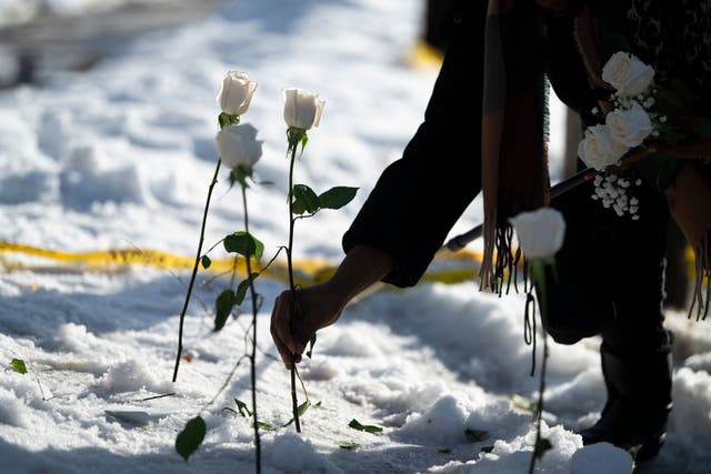<p>A person places a flower at the site where a woman was reportedly shot and killed by an ICE agent on January 7</p>