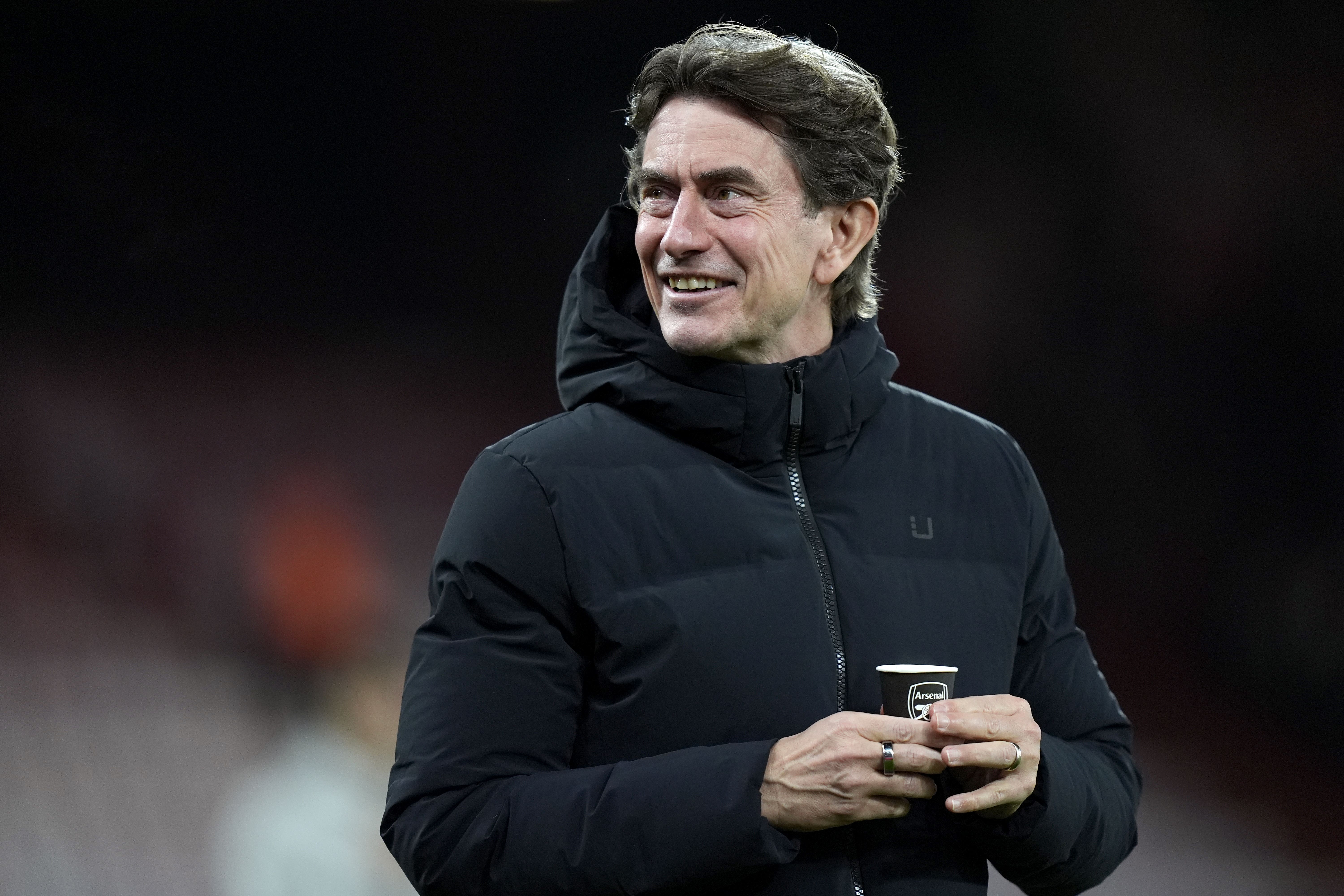 <p>Tottenham manager Thomas Frank holding a cup adorned with the Arsenal badge</p>