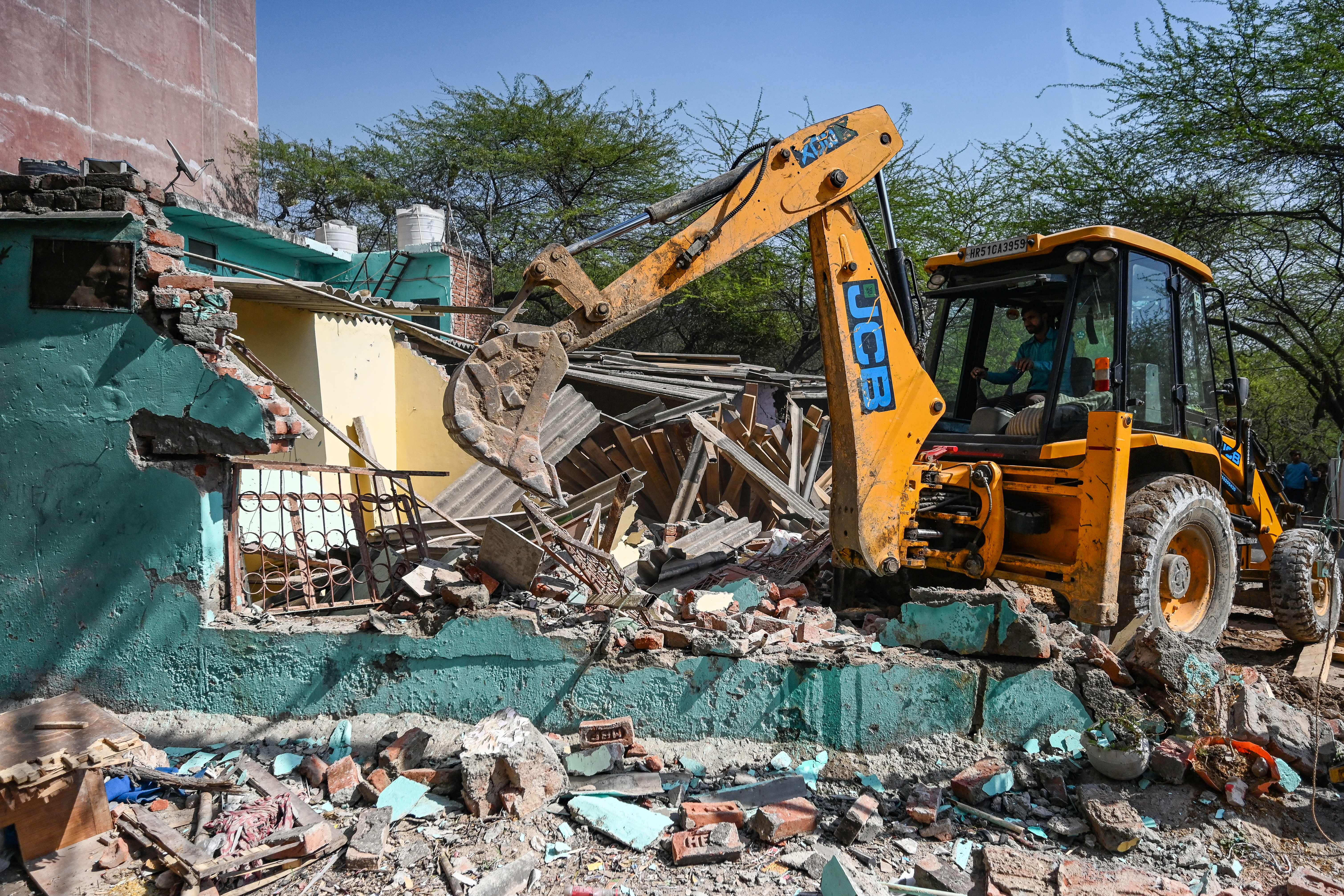 <p>File. Backhoe demolishes a residential building in Delhi on 10 February 2023</p>