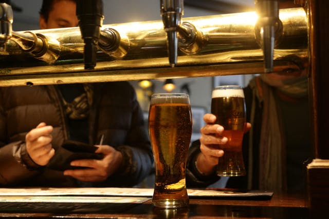 Customers collecting their drinks at the bar of Irish pub O’Neill’s in Carnaby Street, central London.