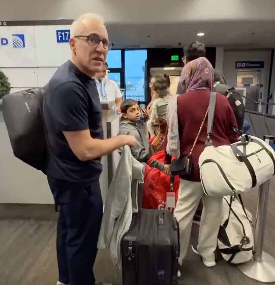 An angry United Airlines passenger was confronted by others in the line over his demand to go before a family with young kids.
