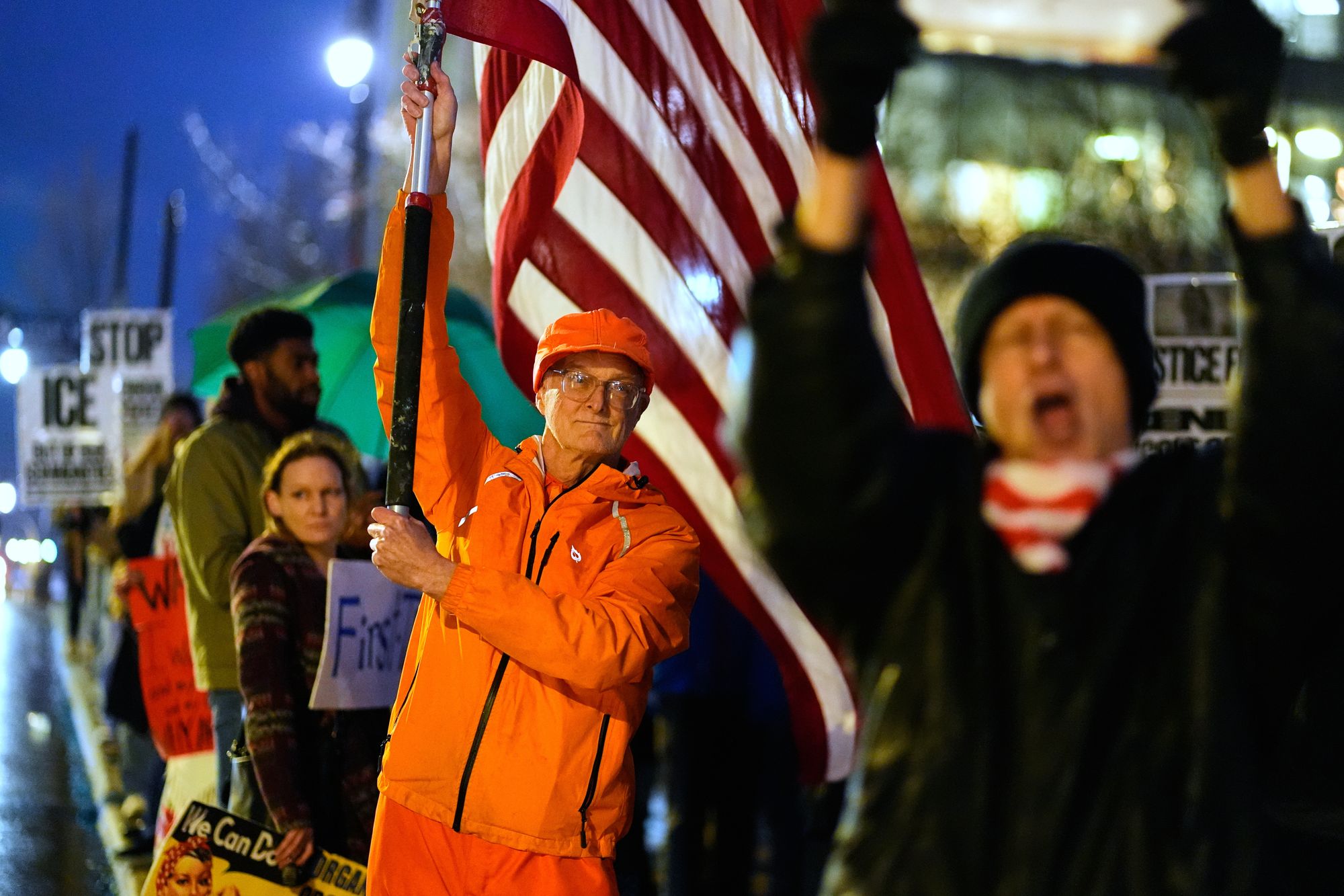 Bill Drummond, center, stands with other protesters during a rally for Renee Good, who was fatally shot by an ICE officer in Minneapolis the day before