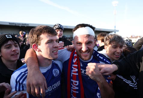 <p>The bandaged Dawson, captain and scorer of Macclesfield's first goal, celebrates with fans on the pitch </p>