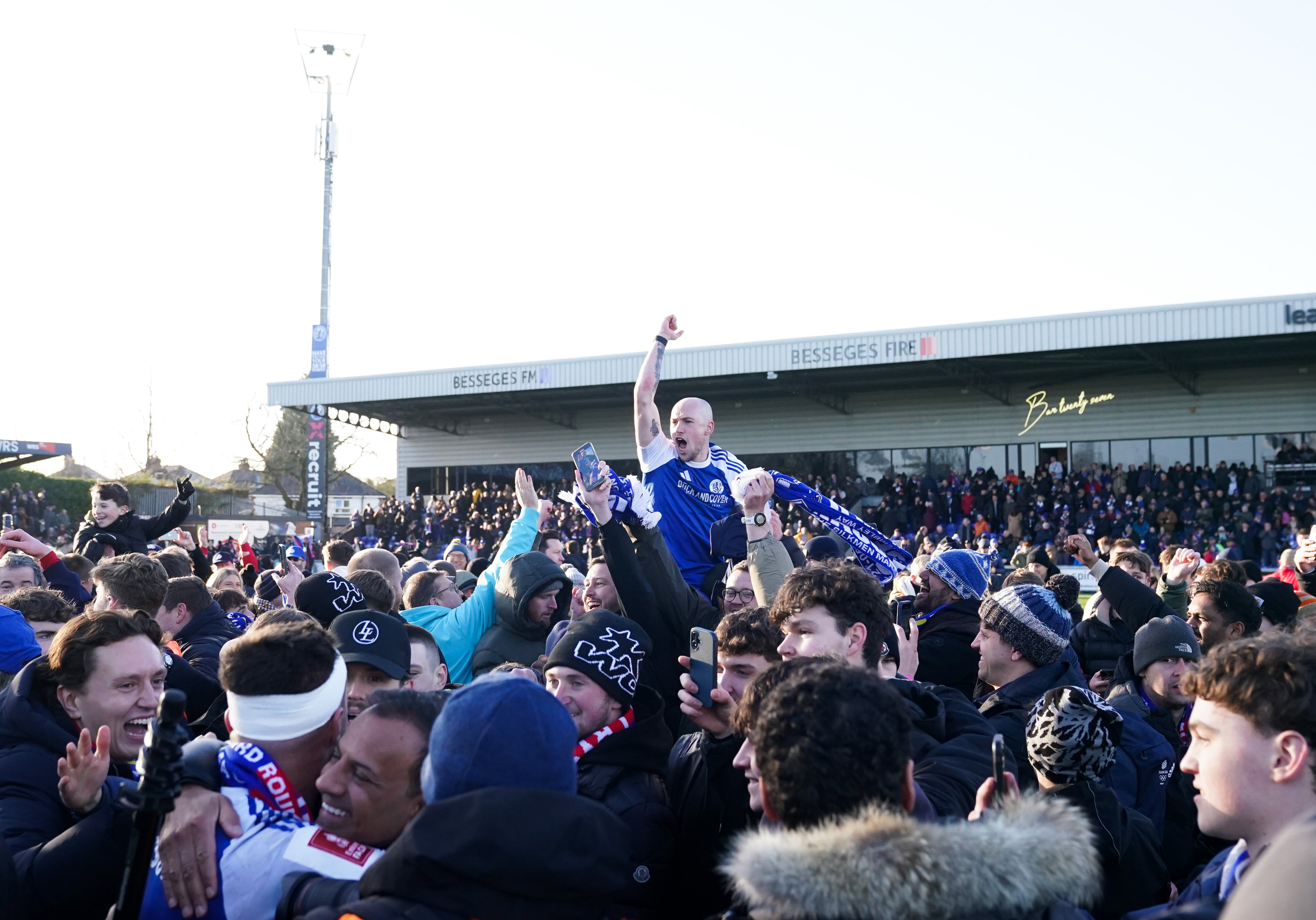 <p>Macclesfield’s Josh Kay celebrates with fans on the pitch after the sixth-tier club made FA Cup history by beating Crystal Palace</p>
