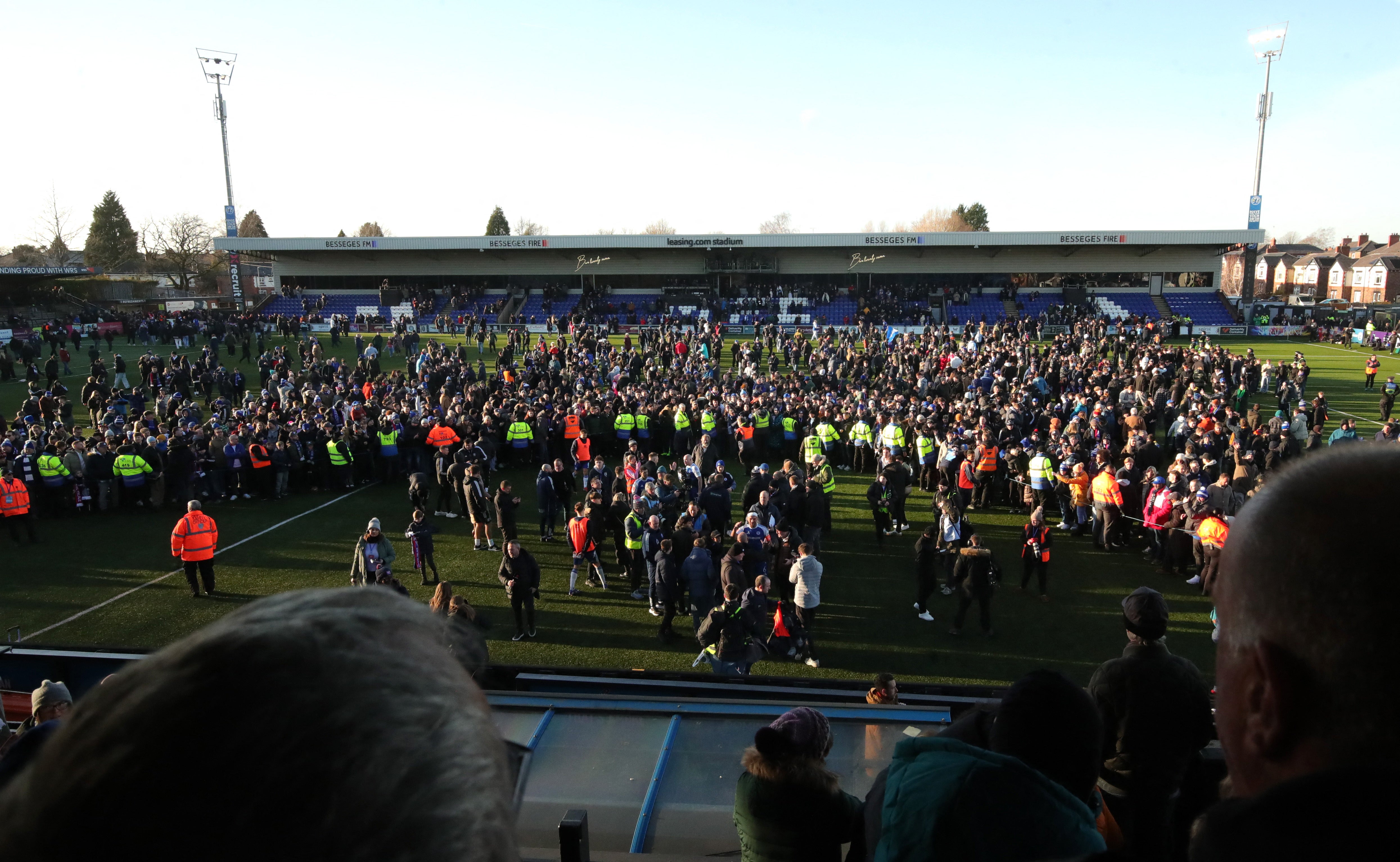 <p>Macclesfield F.C.'s fans and players celebrate on the pitch after the match </p>