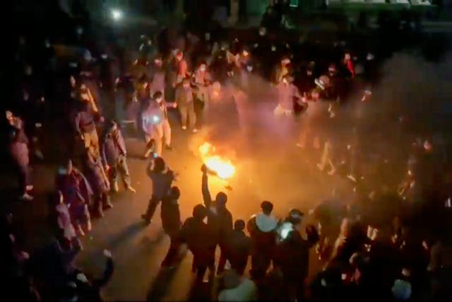<p>Protesters dancing around a bonfire on a street in Tehran (UGC via AP)</p>