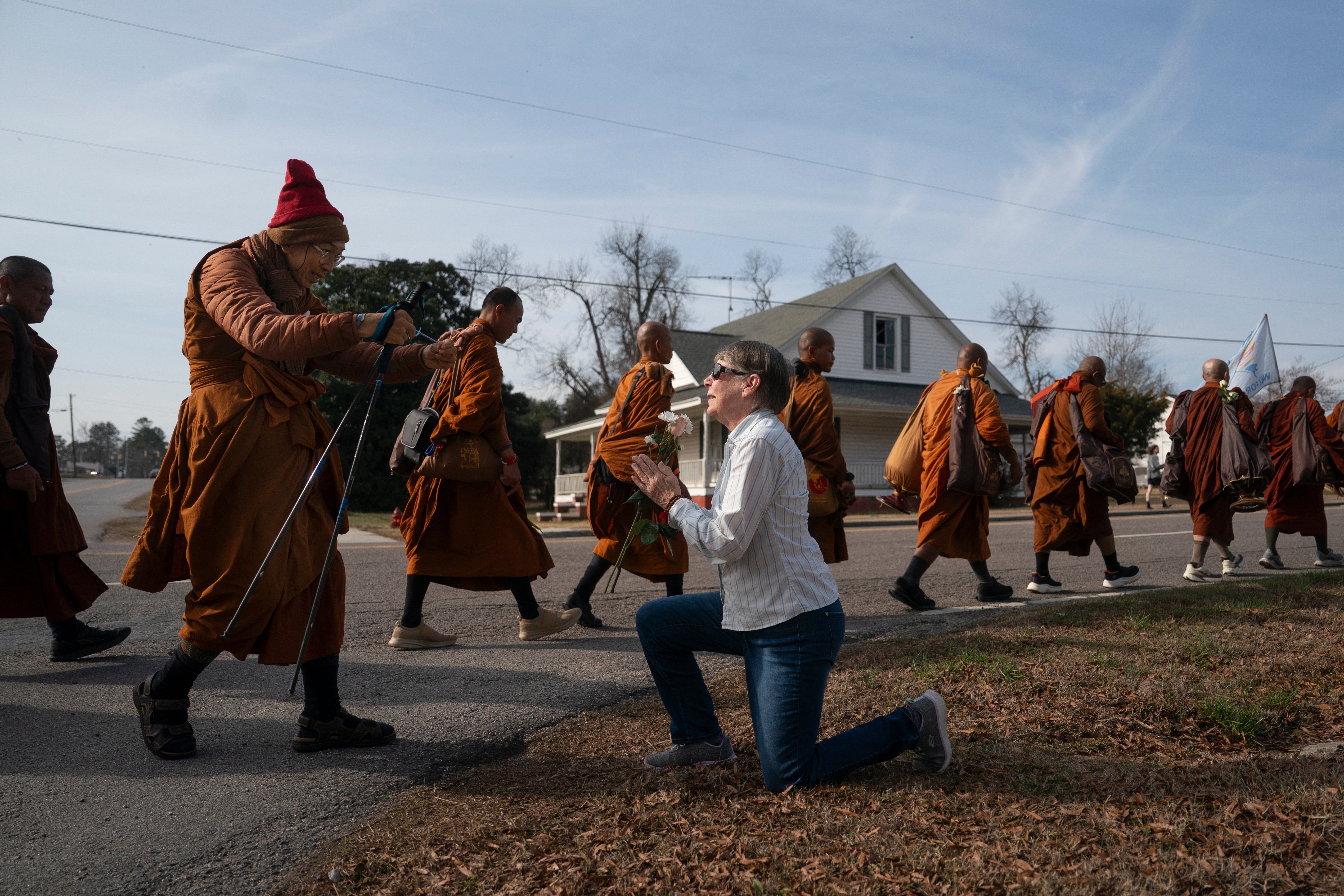 Audrie Pearce greets Buddhist monks who are participating in the, 