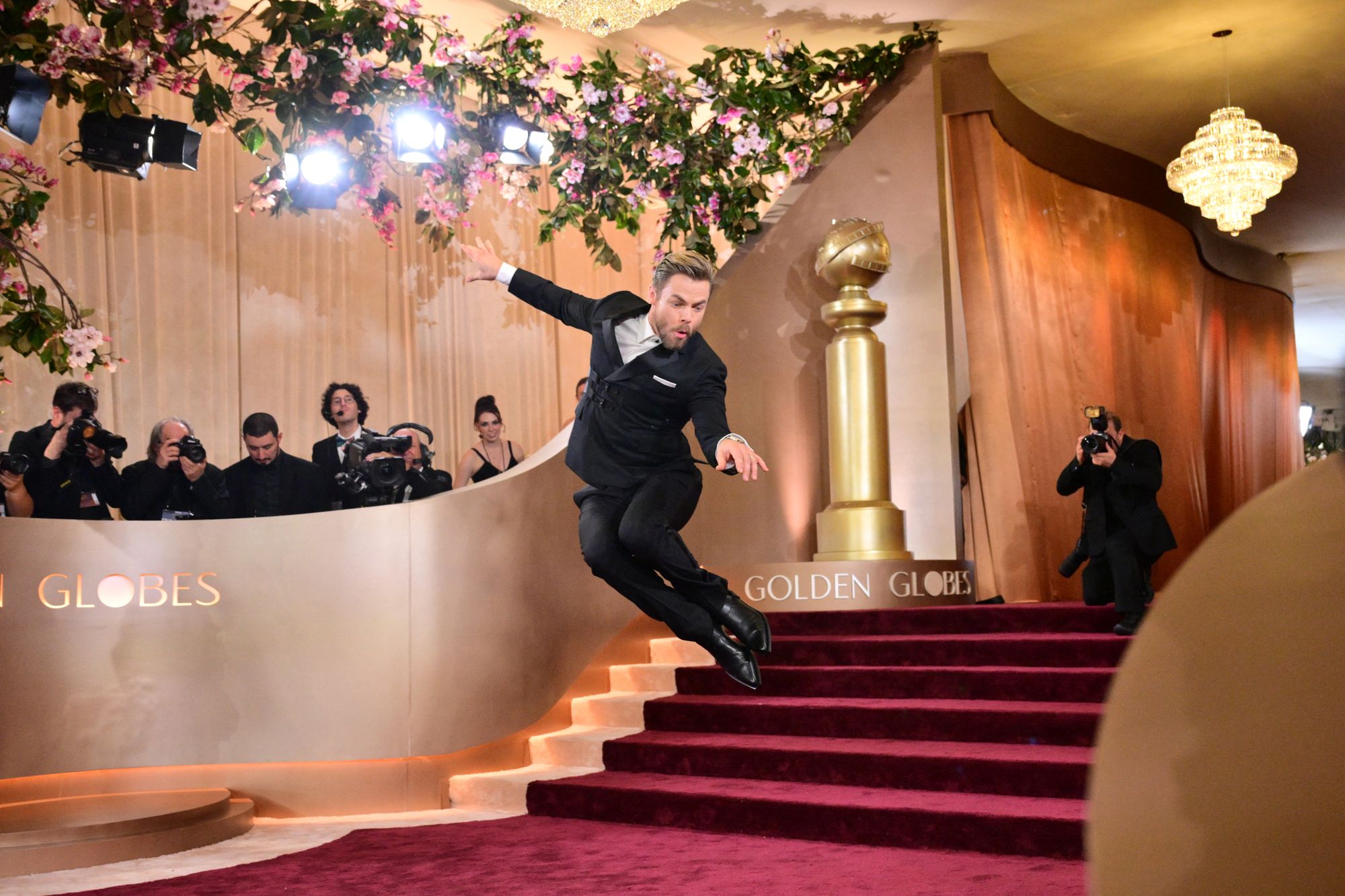 Derek Hough jumping on the steps of the 83rd annual Golden Globes