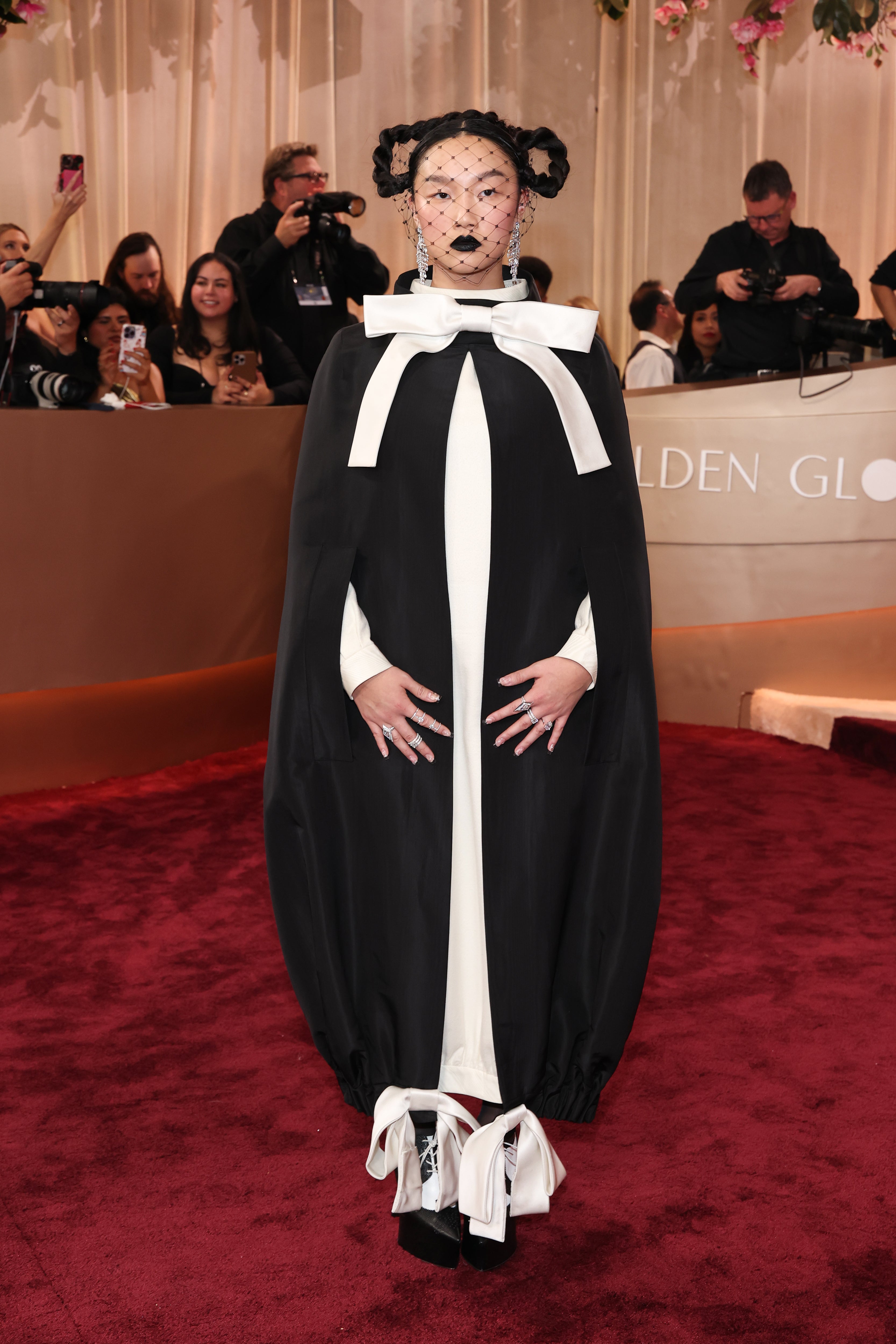 Singer Audrey Nuna took a risk wearing a Thom Browne ensemble with a black cape and large white bows at both the top of the outfit, as well as tied around each of her ankles