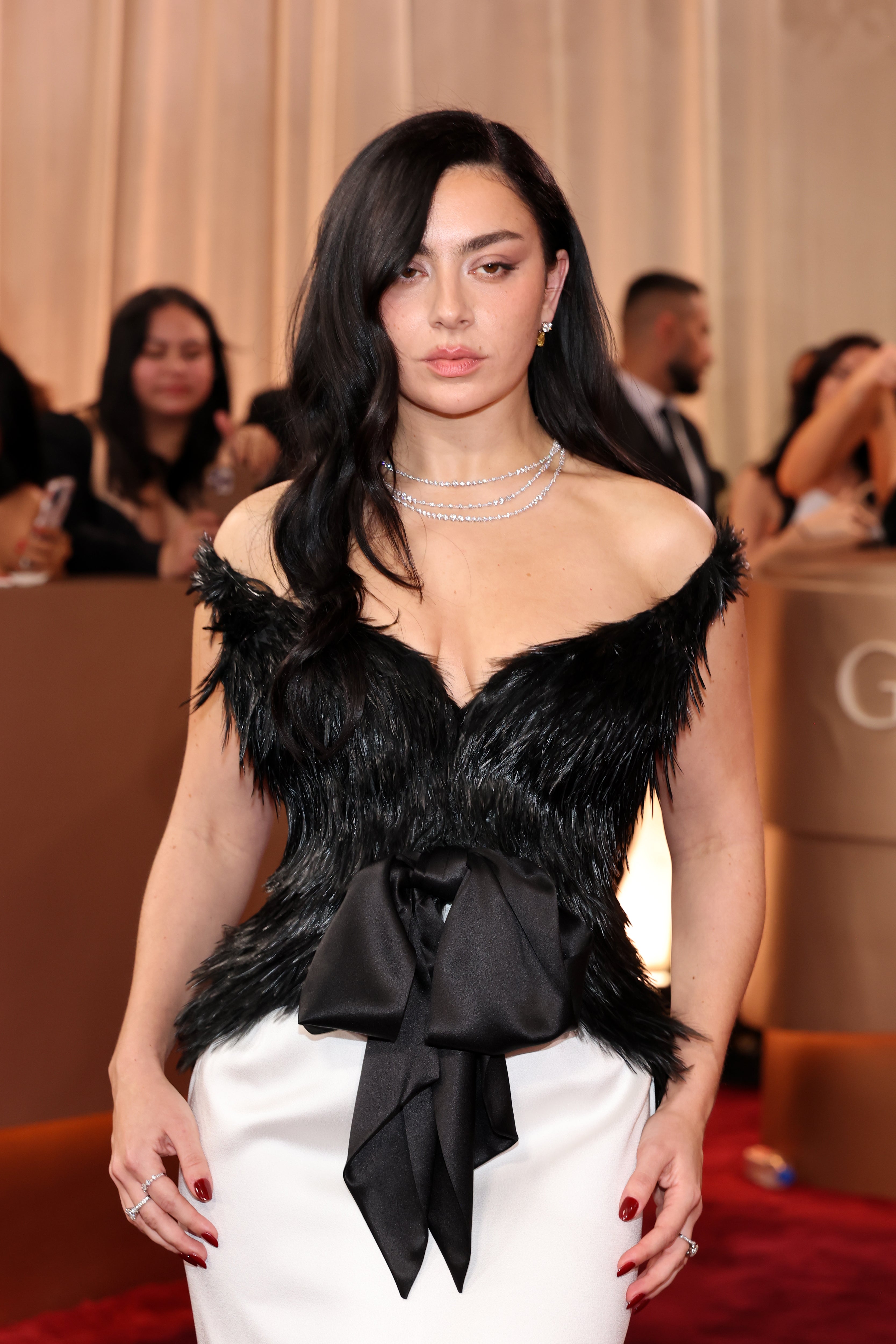 Charli xcx appeared at the Golden Globes wearing a black and white Saint Laurent gown. The black corset looked to be made of either feathers or fur, a busy and stark contrast to the white skirt