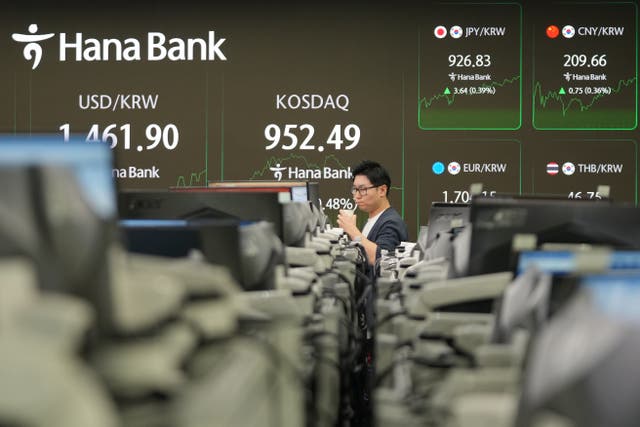 <p>A dealer walks near the screens showing the foreign exchange rate between U.S. dollar and South Korean won and the Korean Securities Dealers Automated Quotations (KOSDAQ) at a dealing room of Hana Bank in Seoul, South Korea, Monday, Jan. 12, 2026. (AP Photo/Lee Jin-man)</p>