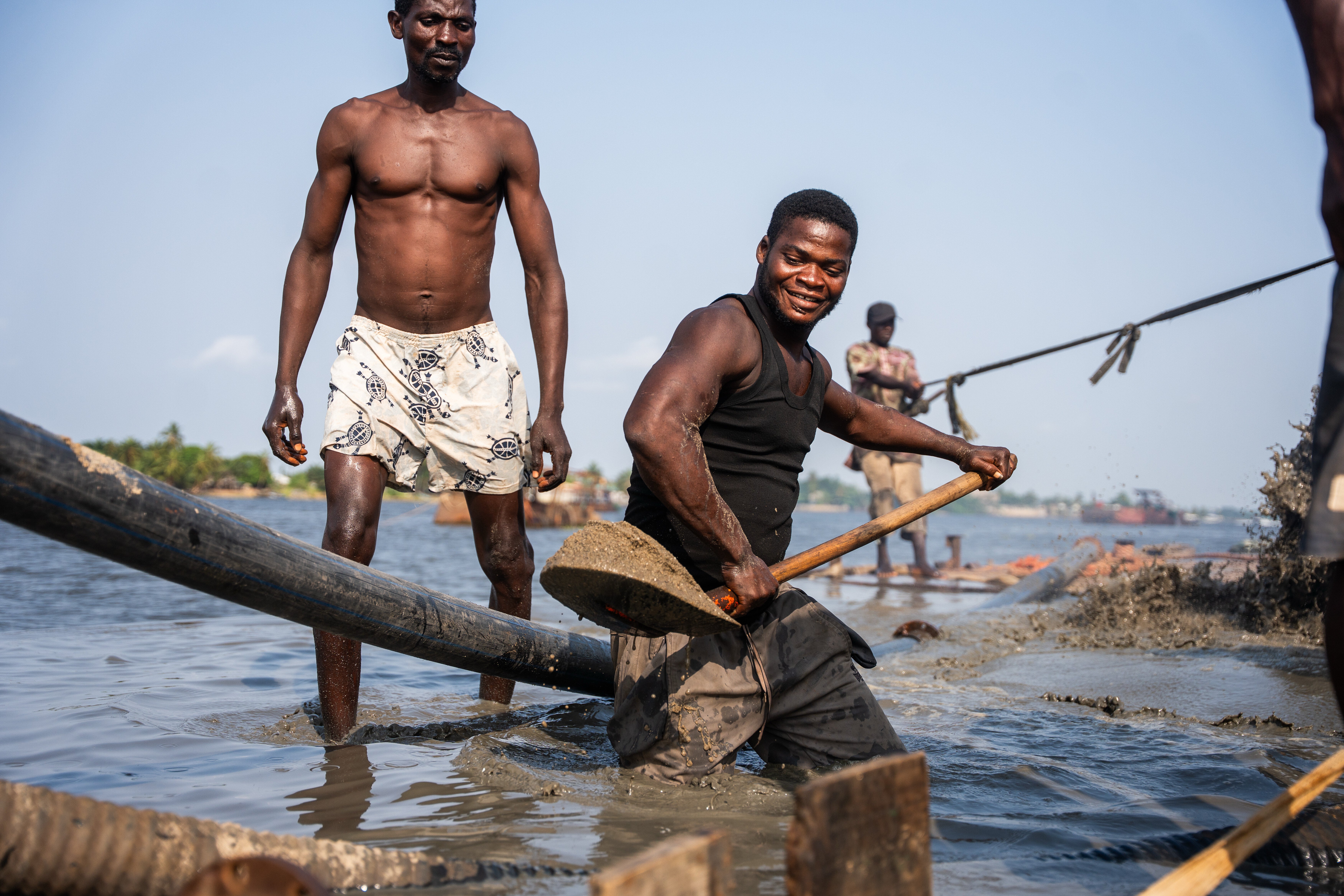 Worker shovels up freshly extracted sharp sand from a dredging transporter in Ibeshe, Lagos, Nigeria, on Saturday, Dec. 6, 2025. (AP Photo/Grace Ekpu)