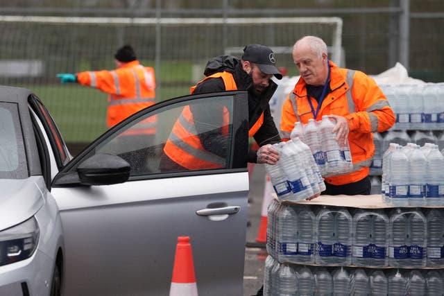<p>Workers hand over bottled water at a water station in East Grinstead, after bad weather was blamed for more water outages in Kent</p>