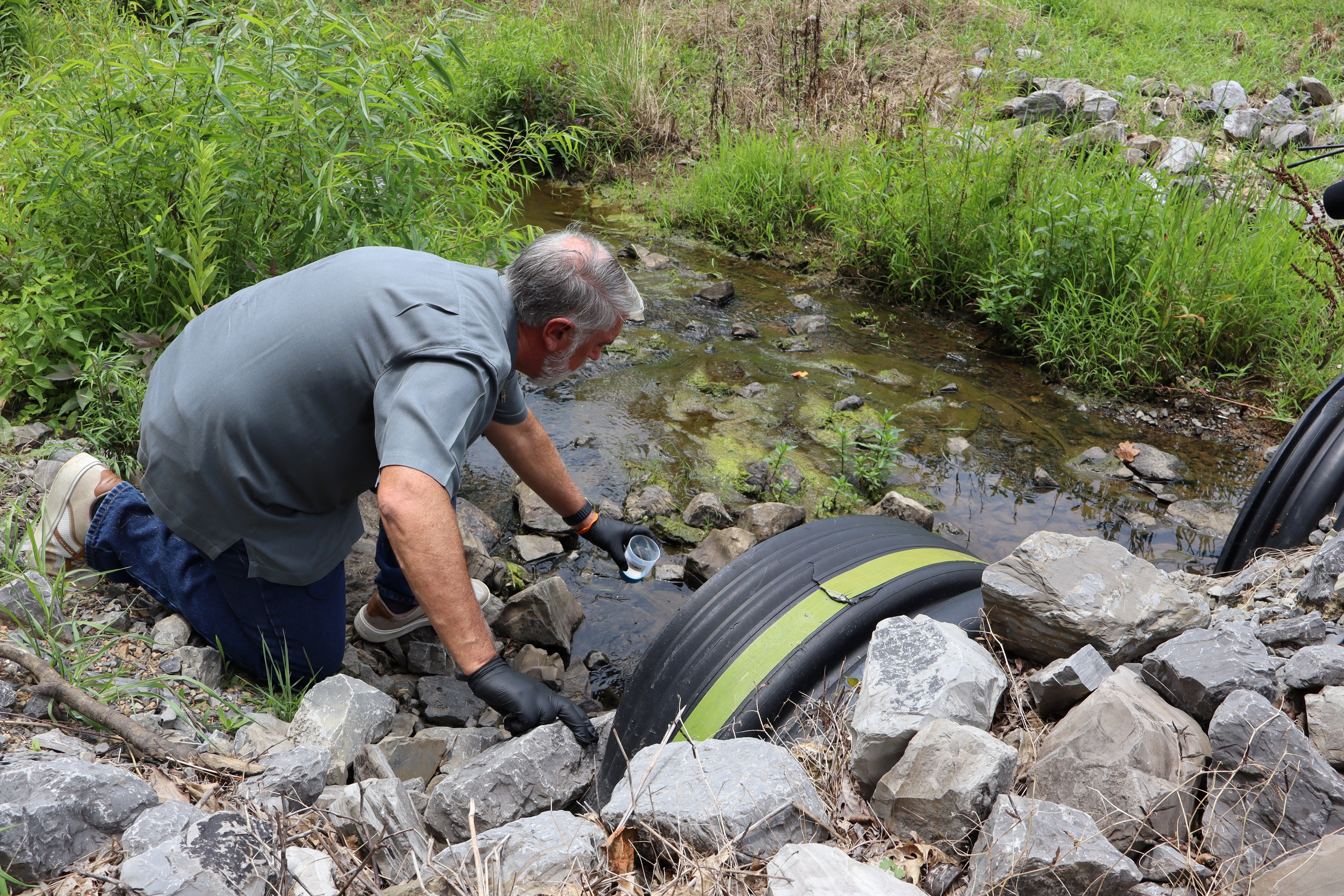 A Georgia man tests a creek on his property for forever chemicals in June. Half of U.S. drinking water has at least one forever chemical in it