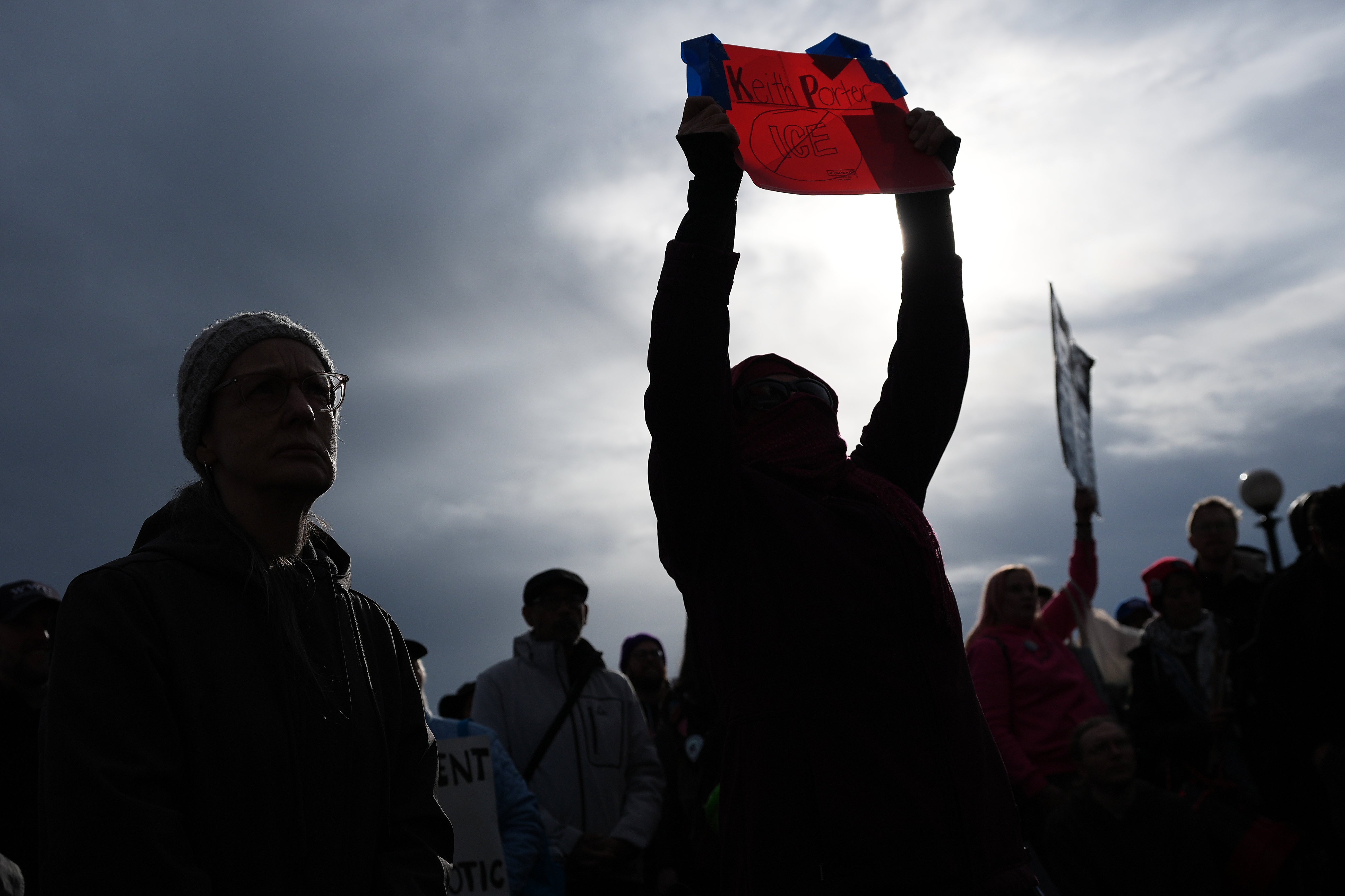 A demonstrator holds a sign for Keith Porter, who was fatally shot by an off-duty ICE agent after allegedly firing a gun into the air on New Year’s Eve