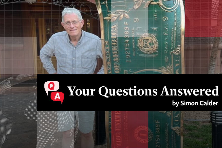 <p>Simon Calder beside a sculpture of a dollar bill in Aspen, Colorado </p>