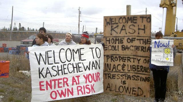 <p>An undated photo shows residents holding signs calling for improved conditions at the Kashechewan First Nations Reserve in Ontario. Access to clean drinking water has been an ongoing issue for the community, according to local media outlets</p>