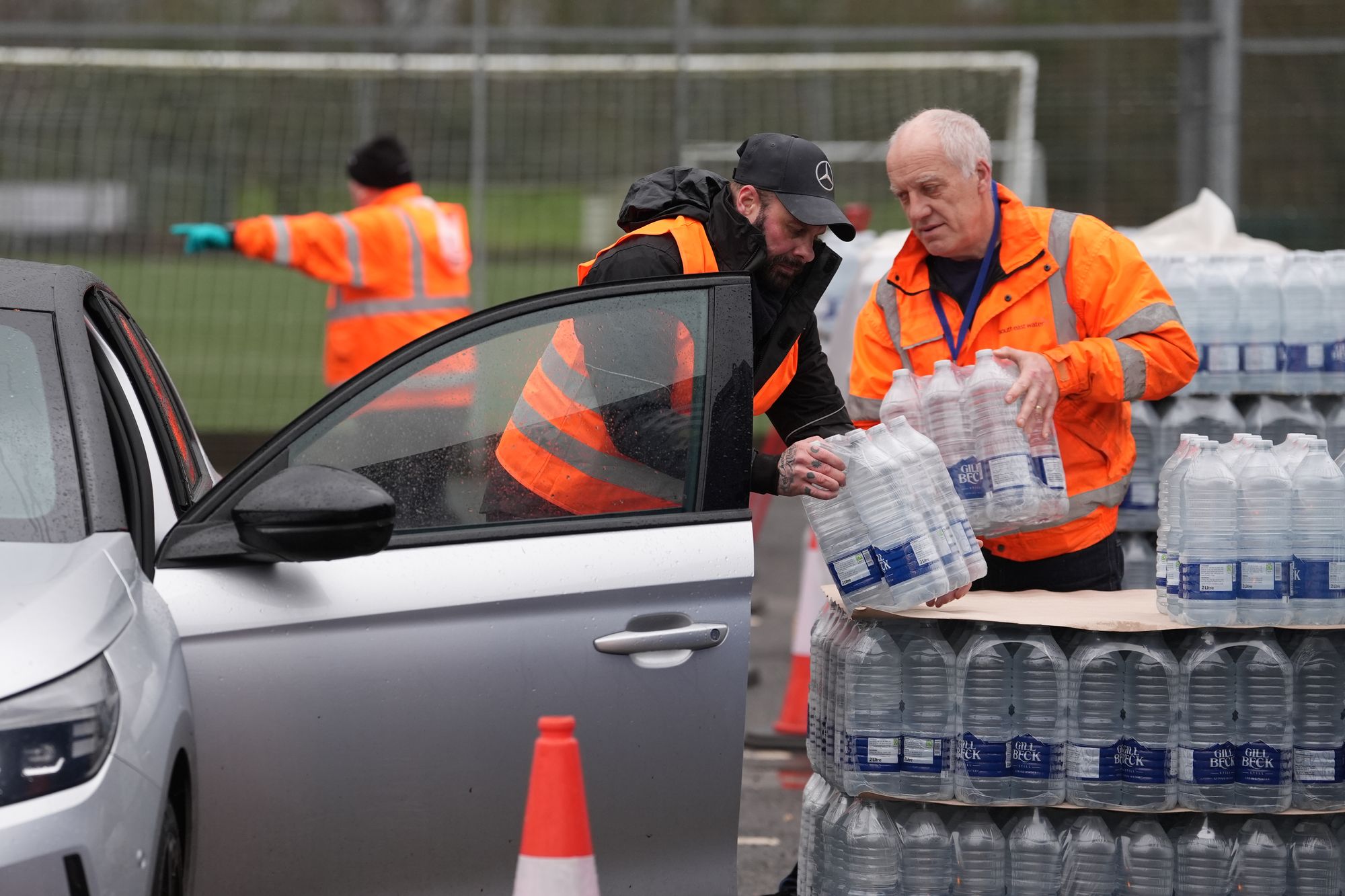 <p>Workers hand over bottled water at a water station in East Grinstead, after bad weather was blamed for more water outages in Kent and parts of Sussex</p>