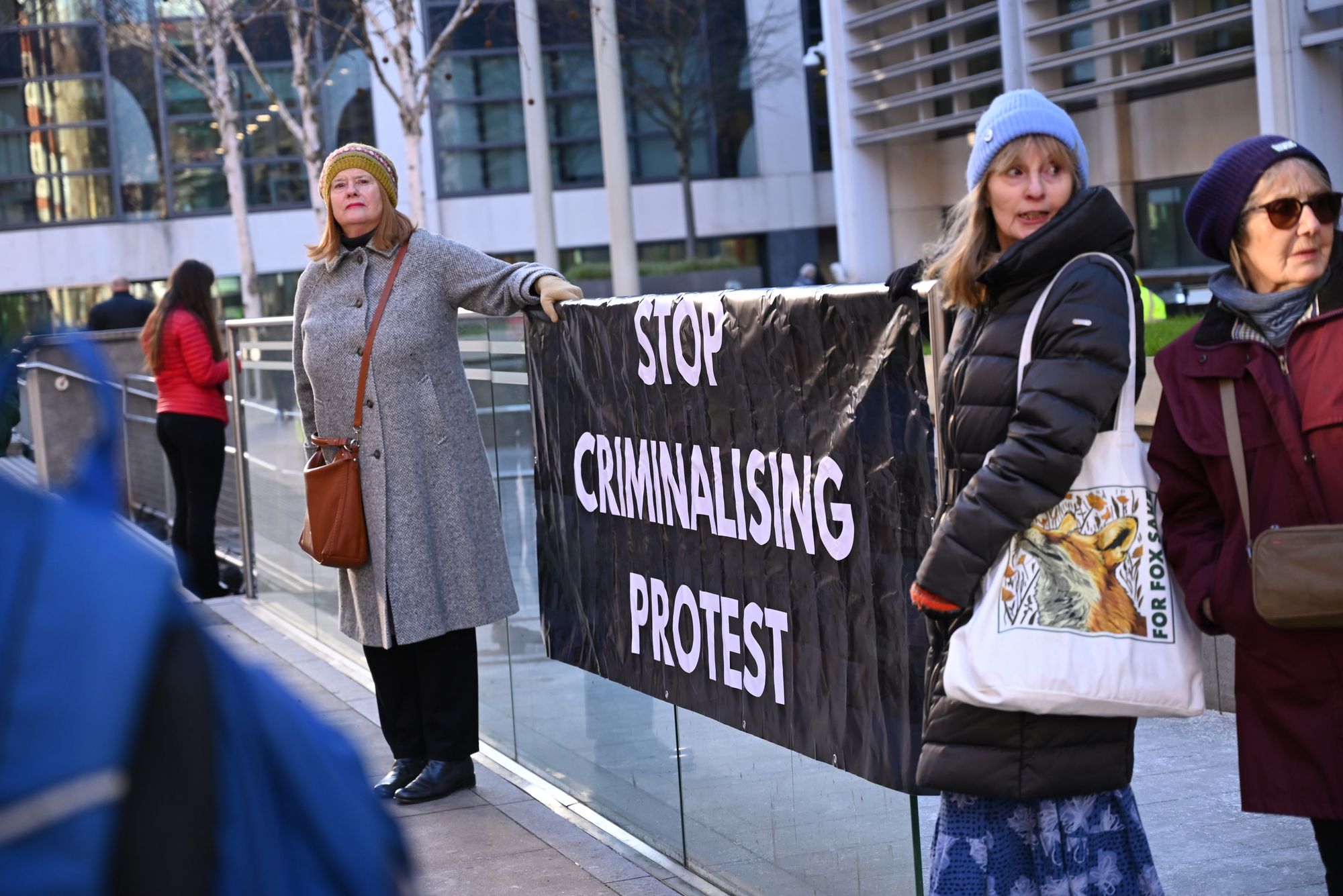 <p>Two women holding banner reading Stop Criminalising Protest</p>