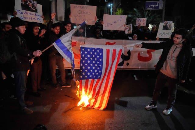 <p>Pro-government protesters burn representations of the U.S. and the Israeli flags in front of the British Embassy, in Tehran, Iran,.</p>