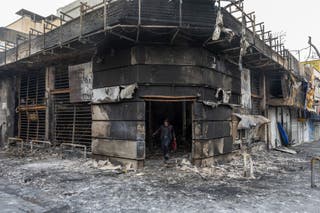 A person exits a burned out building on January 10, 2026 in Tehran, Iran