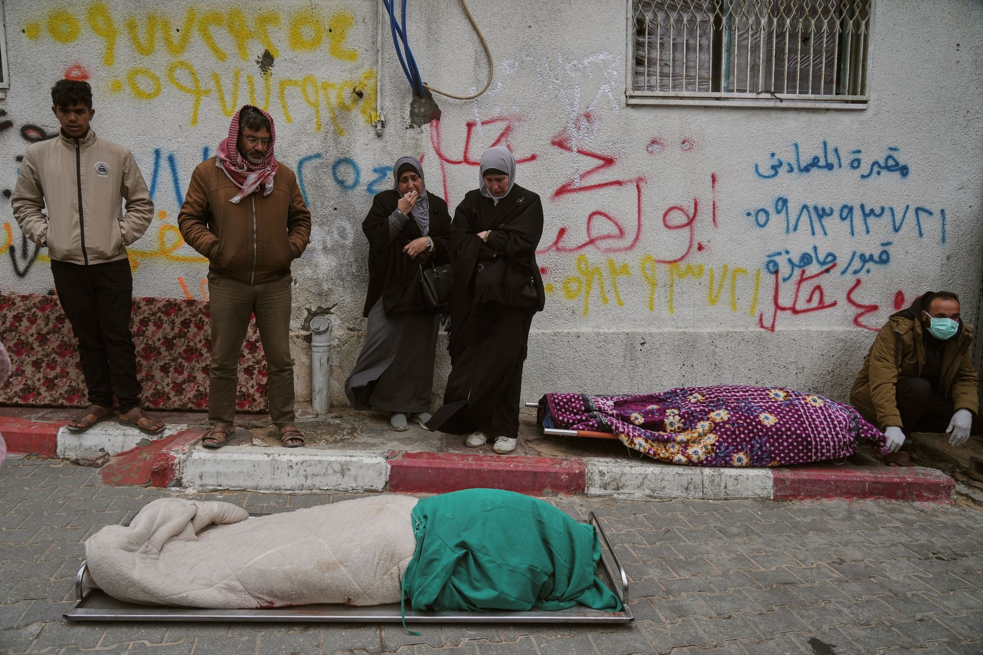 Members of the Hamouda family bid farewell to relatives who died after a damaged building collapsed onto their tents during a storm in Gaza City
