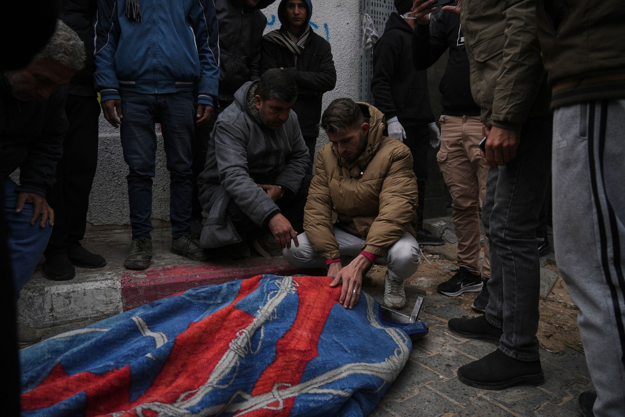 Members of the Hamouda family bid farewell to relatives who died after a damaged building collapsed onto their tents during a storm in Gaza City