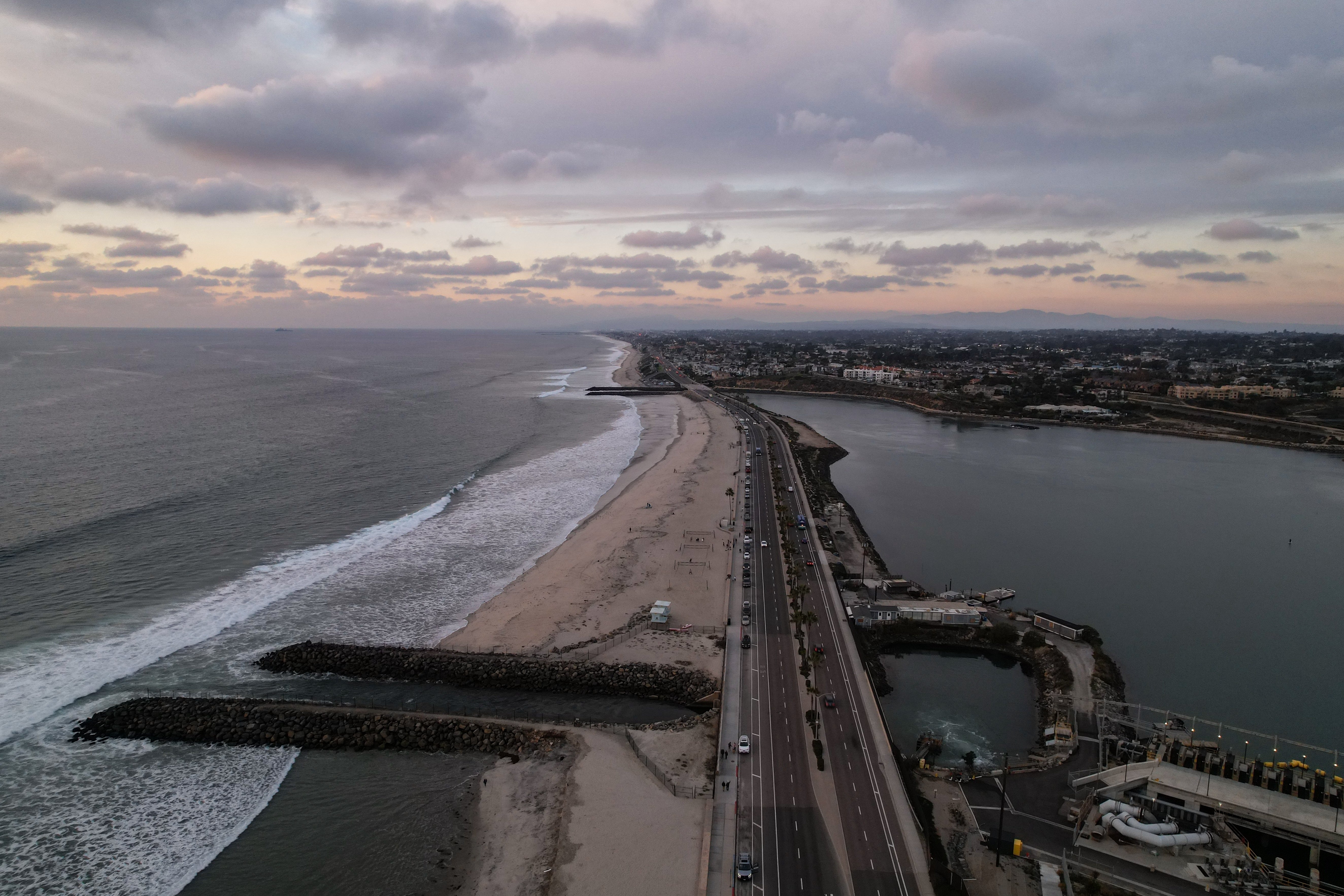 A drone view shows the Carlsbad desalination plant's intake lagoon on the right and the discharge canal on the left in Carlsbad, California