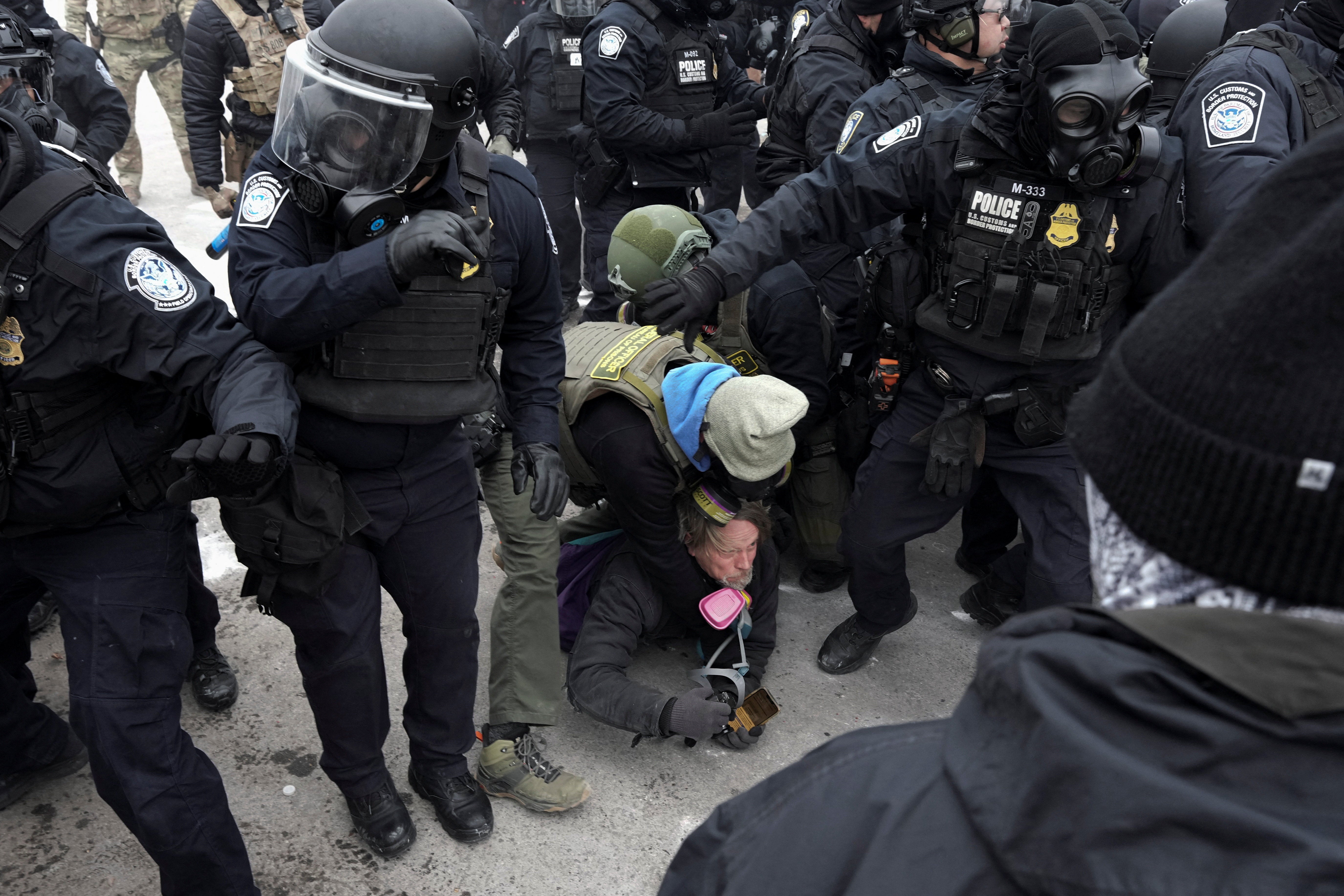 John Abernathy, a local independent photographer is detained during a demonstration outside the Whipple Federal Building, more than a week after a U.S. Immigration and Customs Enforcement (ICE) agent fatally shot Renee Nicole Good on January 7, in Minneapolis, Minnesota, U.S., January 15, 2026