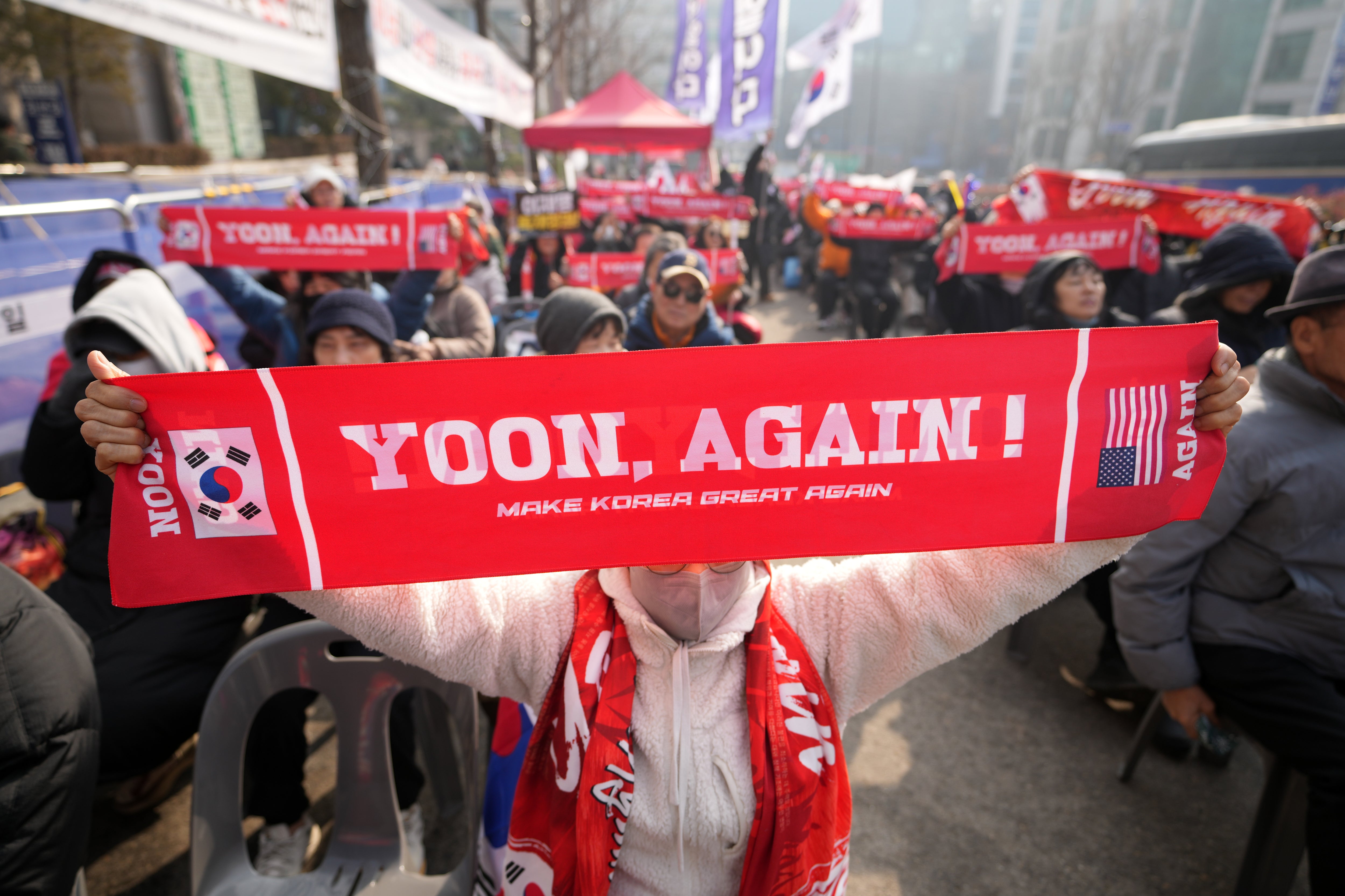 Supporters of Yoon Suk Yeol hold signs outside Seoul Central District Court on Friday