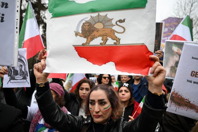 An Anti-Iranian regime protester holds a flag of Iran from before the 1979 revolution, with the lion ad sun emblems, during a demonstration in solidarity with Iranian protestors and "against the Islamic Repuplic for killing Iranian people" in Yalova, on January 16, 2026.