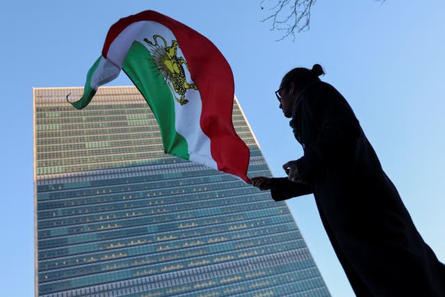 <p>A protester waves the Iranian flag outside UN headquarters </p>