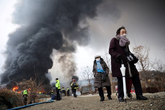 <p>Residents evacuate from the scene amid a fire at Guryong village, the last shantytown in the Gangnam district, in Seoul, South Korea</p>