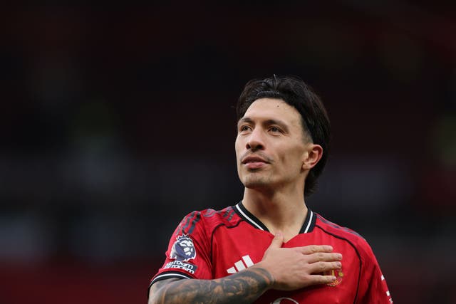 <p>Lisandro Martinez pats the badge after the derby win over Manchester City</p>