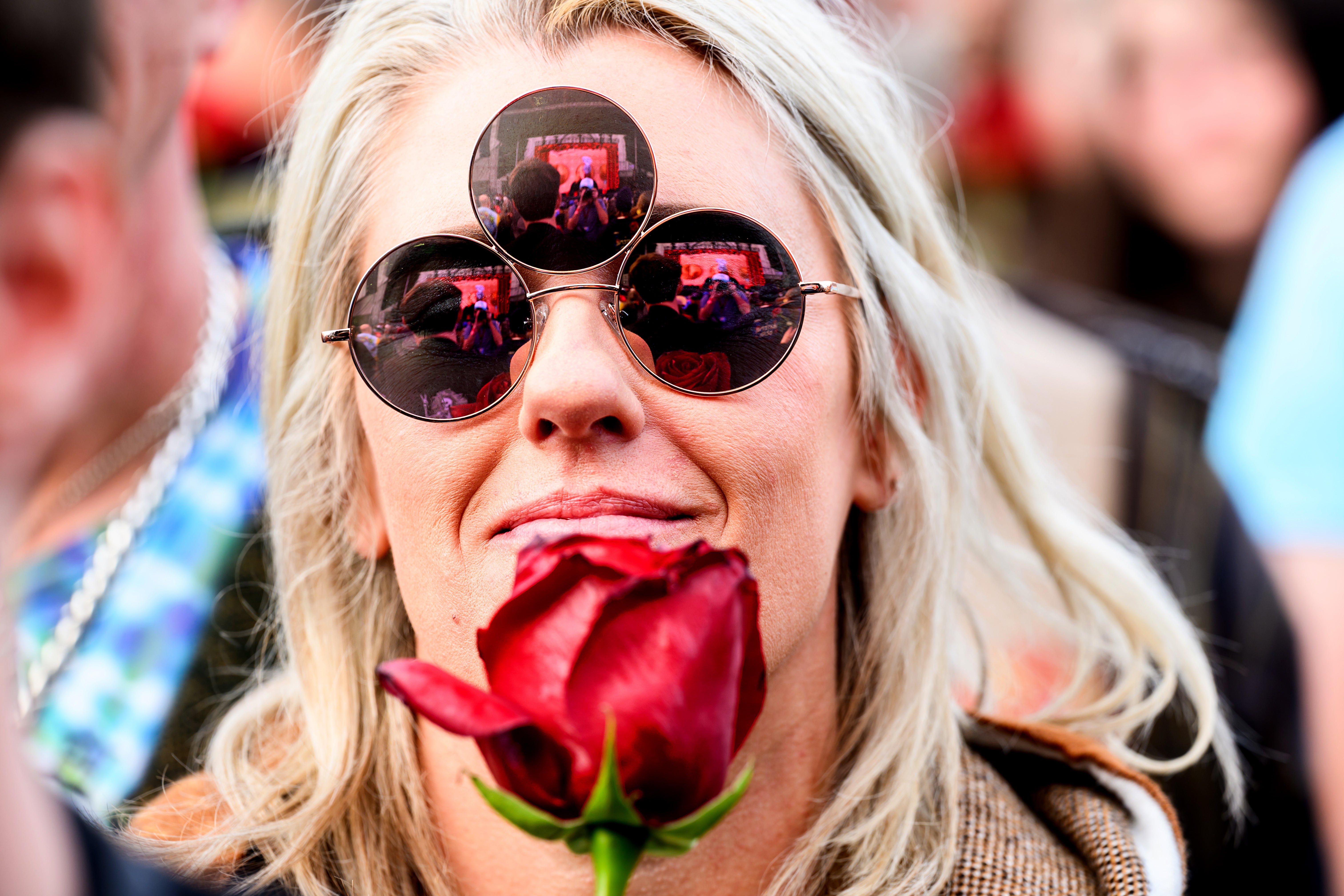 Sarah Black holds a rose while attending a public memorial for Grateful Dead guitarist Bob Weir