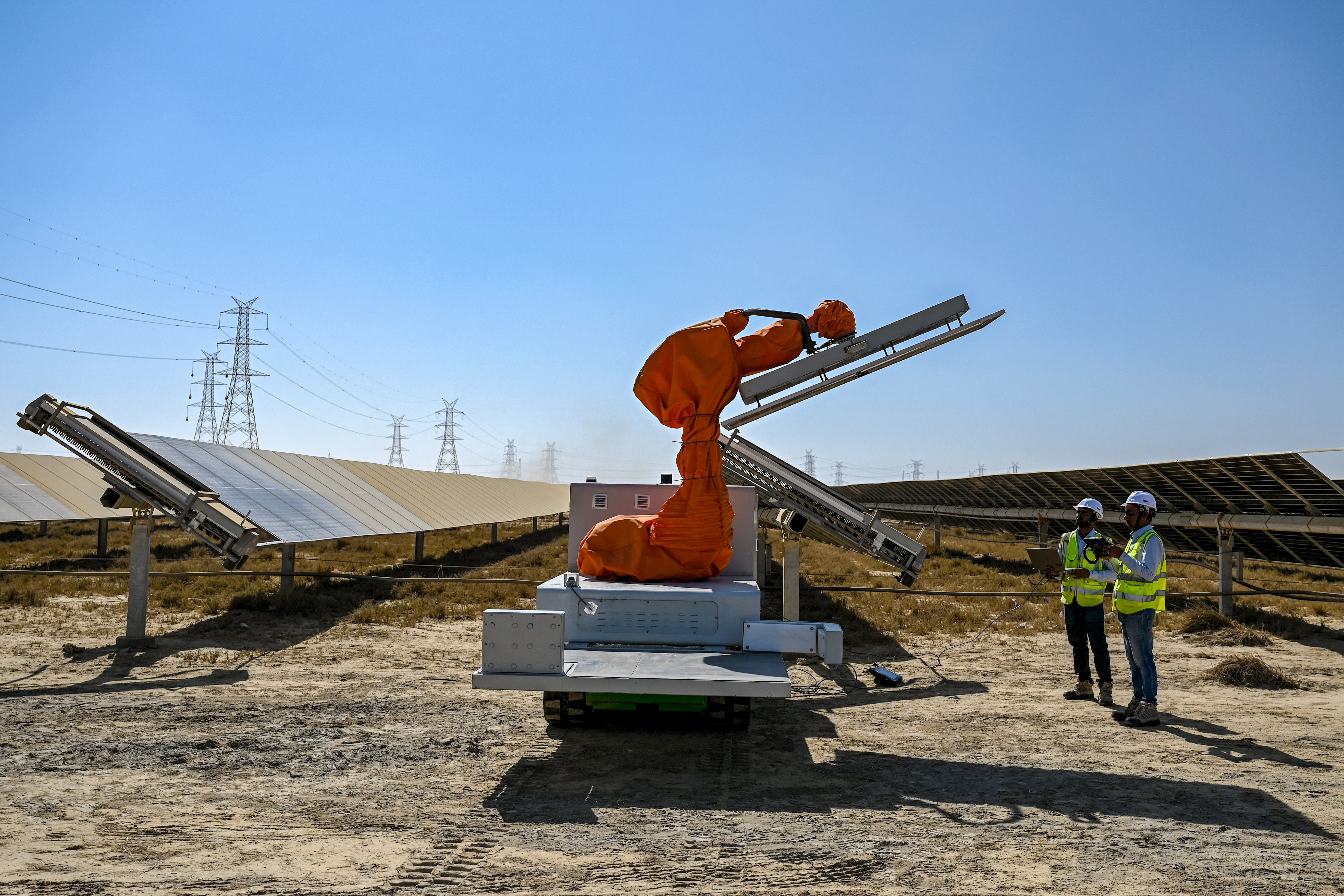 Workers operating a machine during the installation of a solar panel at the Adani Group owned Khavda Renewable Energy Park in Khavda