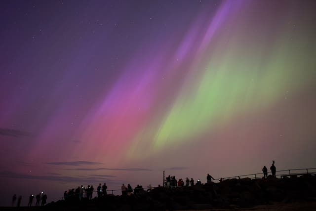 <p>People in Whitley Bay, England, gather to see the aurora borealis, commonly known as the northern lights, on 10 May, 2024. The UK Met Office said a severe solar storm will bring the celestial spectacle on 19 January, 2026</p>