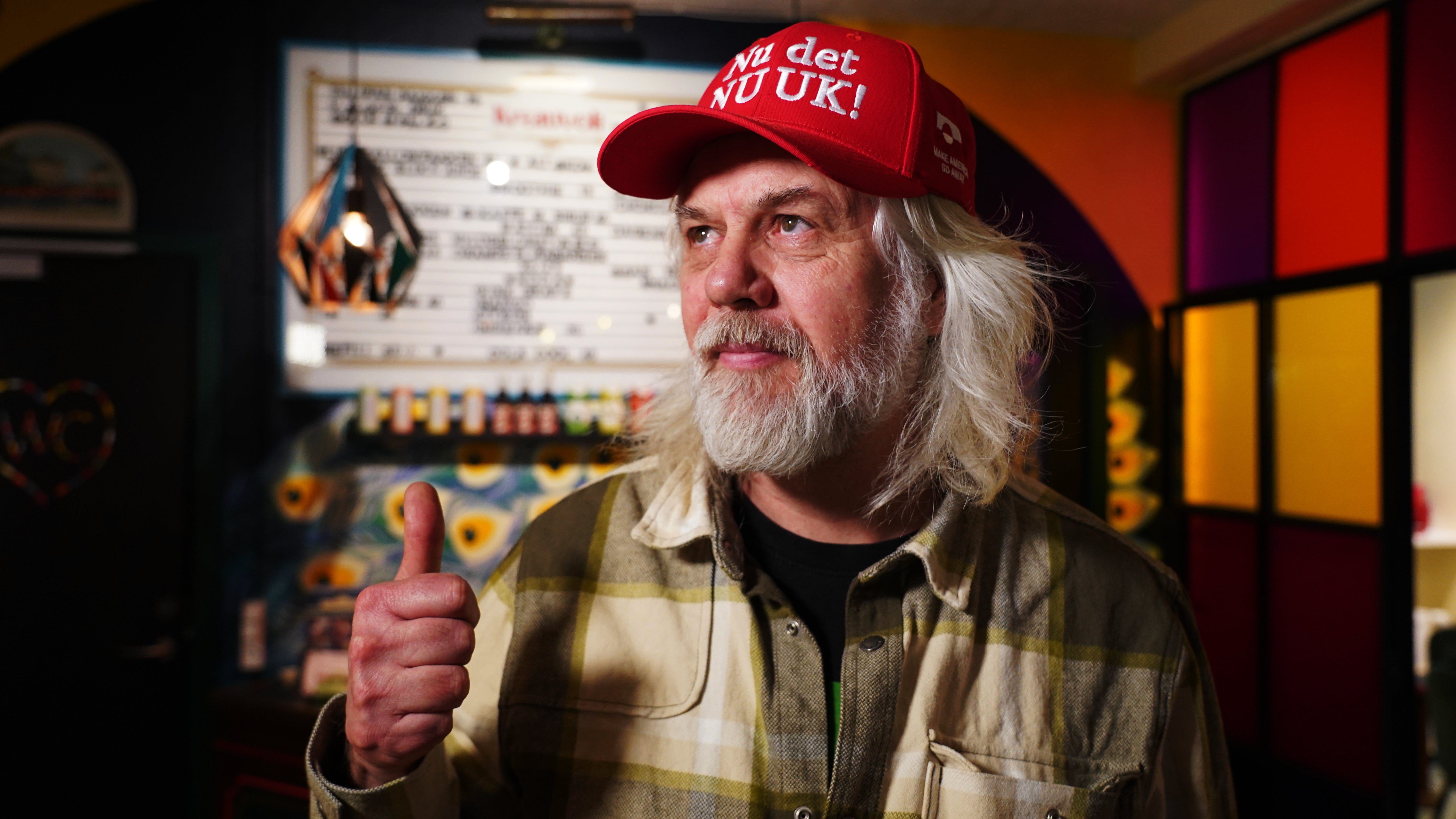 <p>Store owner Jesper Rabe Tonnesen gives a thumbs up as he wears a red cap for sale that he created with the slogan ‘Nu det NUUK!,’ a twist on the Danish phrase ‘Nu det nok,’ meaning ‘Now it’s enough,’ substituting Nuuk, Greenland’s tiny capital, in Copenhagen, Denmark, Thursday, Jan. 15, 2026</p>