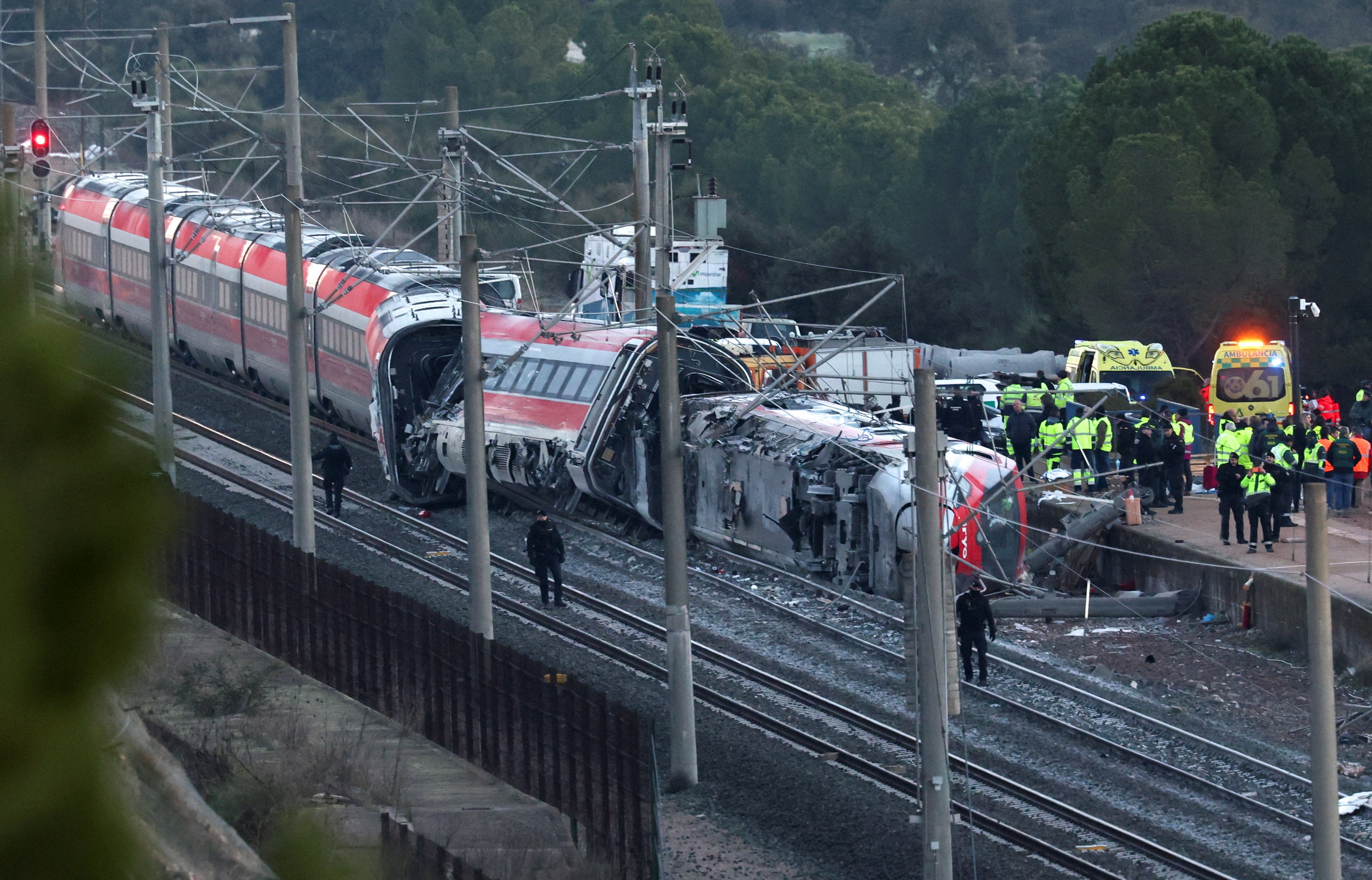 Members of the Spanish Civil Guard, along with other emergency personnel, work next to one of the trains involved in the accident, at the site of a deadly derailment of two high-speed trains near Adamuz, in Cordoba, Spain, January 19, 2026. REUTERS/Susana Vera