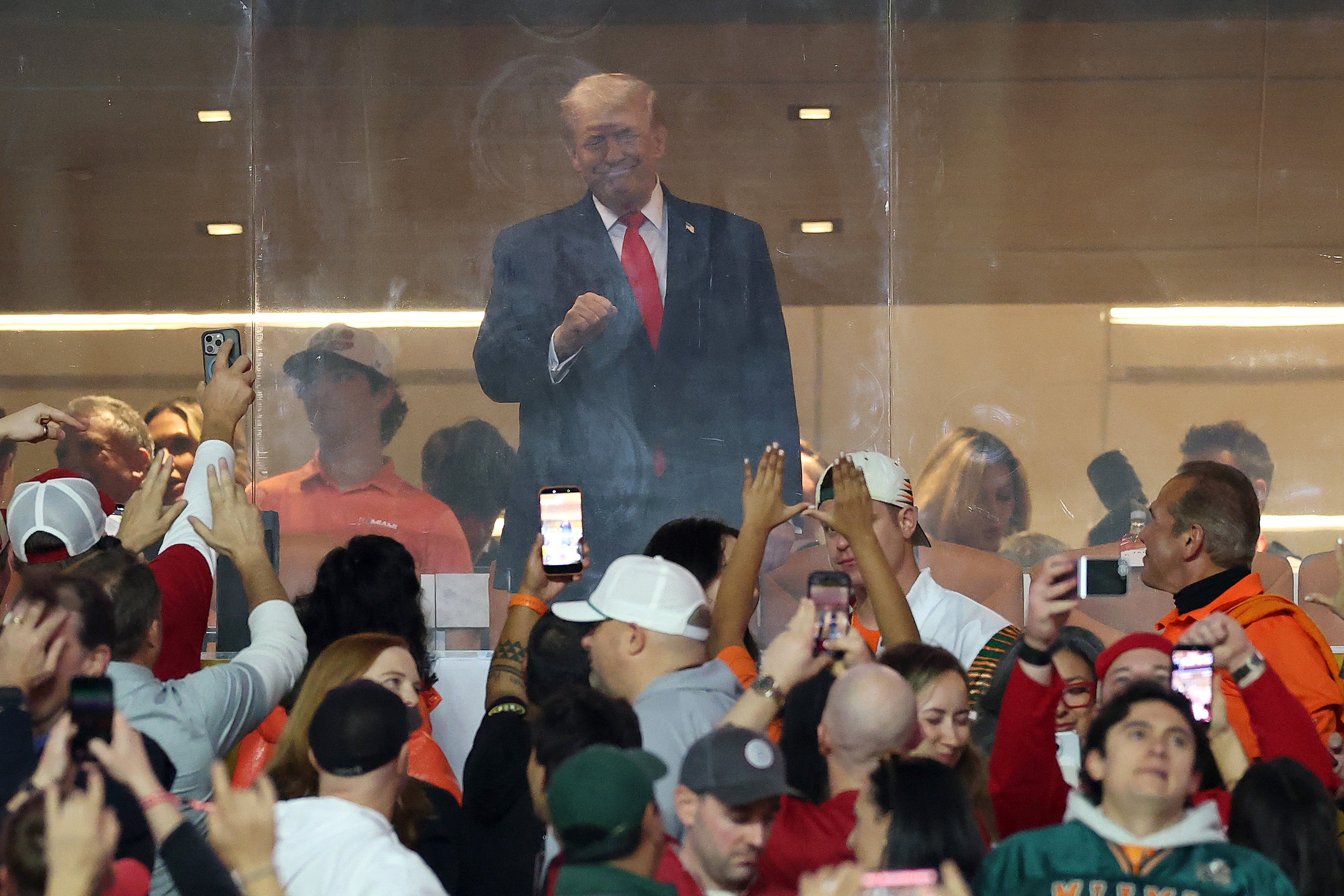 The crowd at the Hard Rock Stadium roared as Trump waved during The Star-Spangled Banner before the Miami Hurricanes and Indiana Hoosiers kicked off the championship game