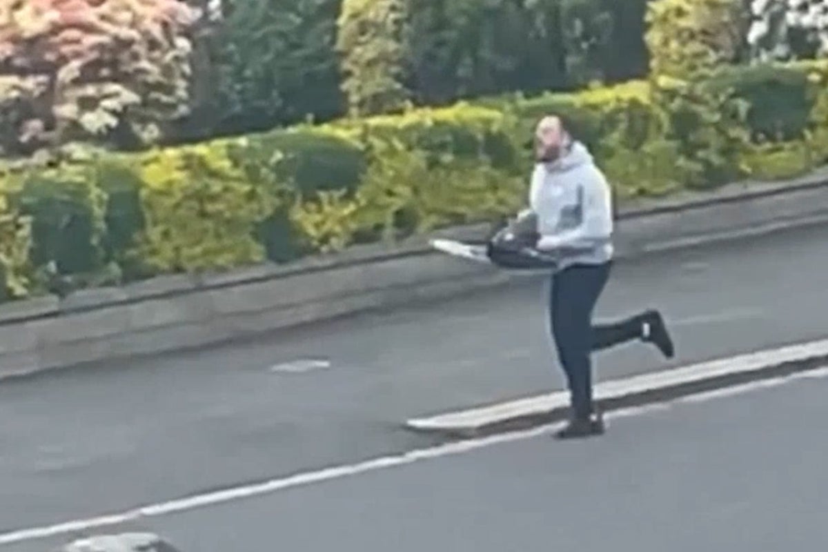 Footage shows chainsaw thug chasing police officer down street