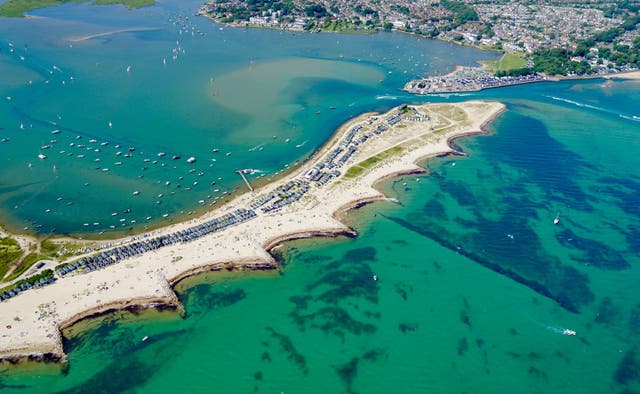 <p>346 beach huts line the stretch of sand at Mudeford Sands, which is at the opening to Christchurch Harbour, with Mudeford Quay at the other side of the entrance</p>