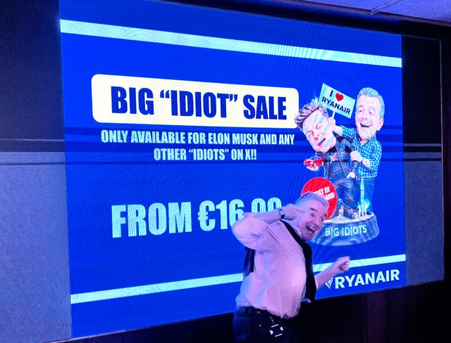 <p>Open to all: Michael O’Leary, chief executive of Ryanair, posing in front of a sales poster featuring Elon Musk</p>