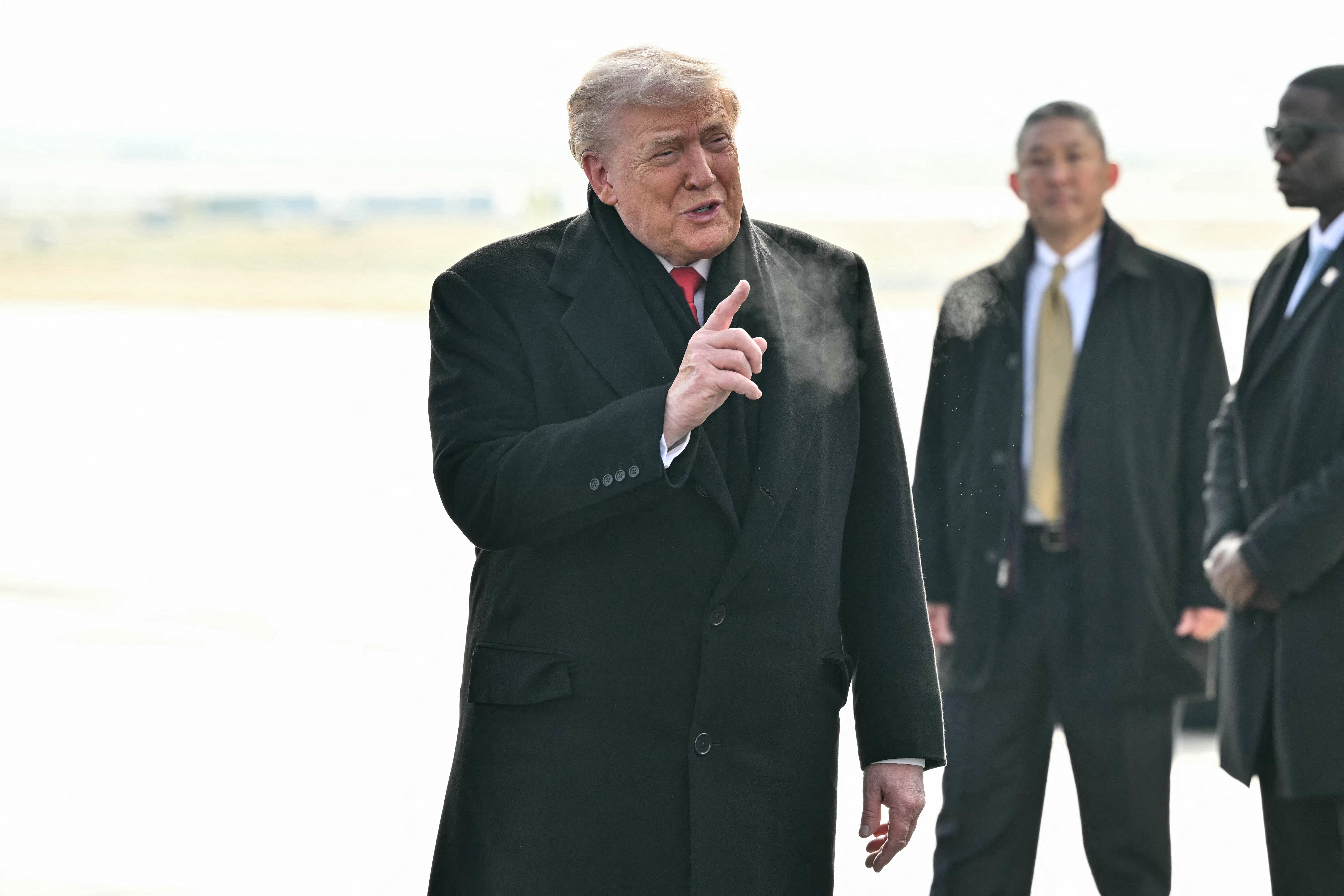 <p>Trump (L) gestures on the tarmac upon arrival at Zurich Airport</p>