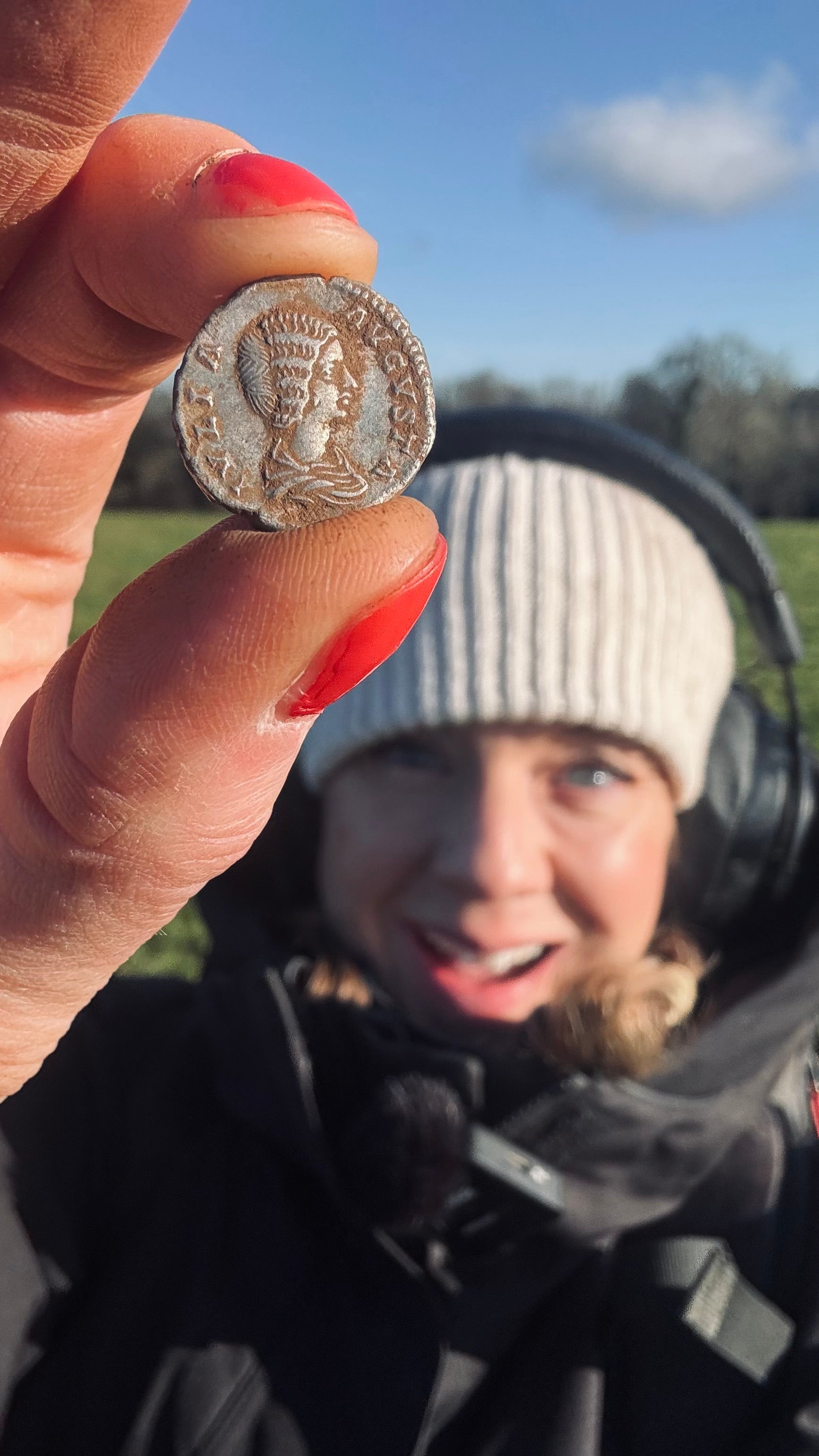 Ms Verrecchia holding a silver coin found in a dig in Wiltshire